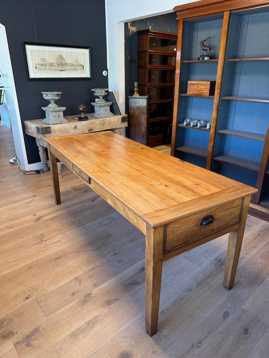 Preciosa mesa antigua francesa de madera de cerezo. La madera de cerezo tiene un hermoso veteado y una preciosa pátina. La mesa está en perfecto estado, con la altura de las patas ajustada a 65 cm sin aumentar la altura total (79 cm). La mesa tiene