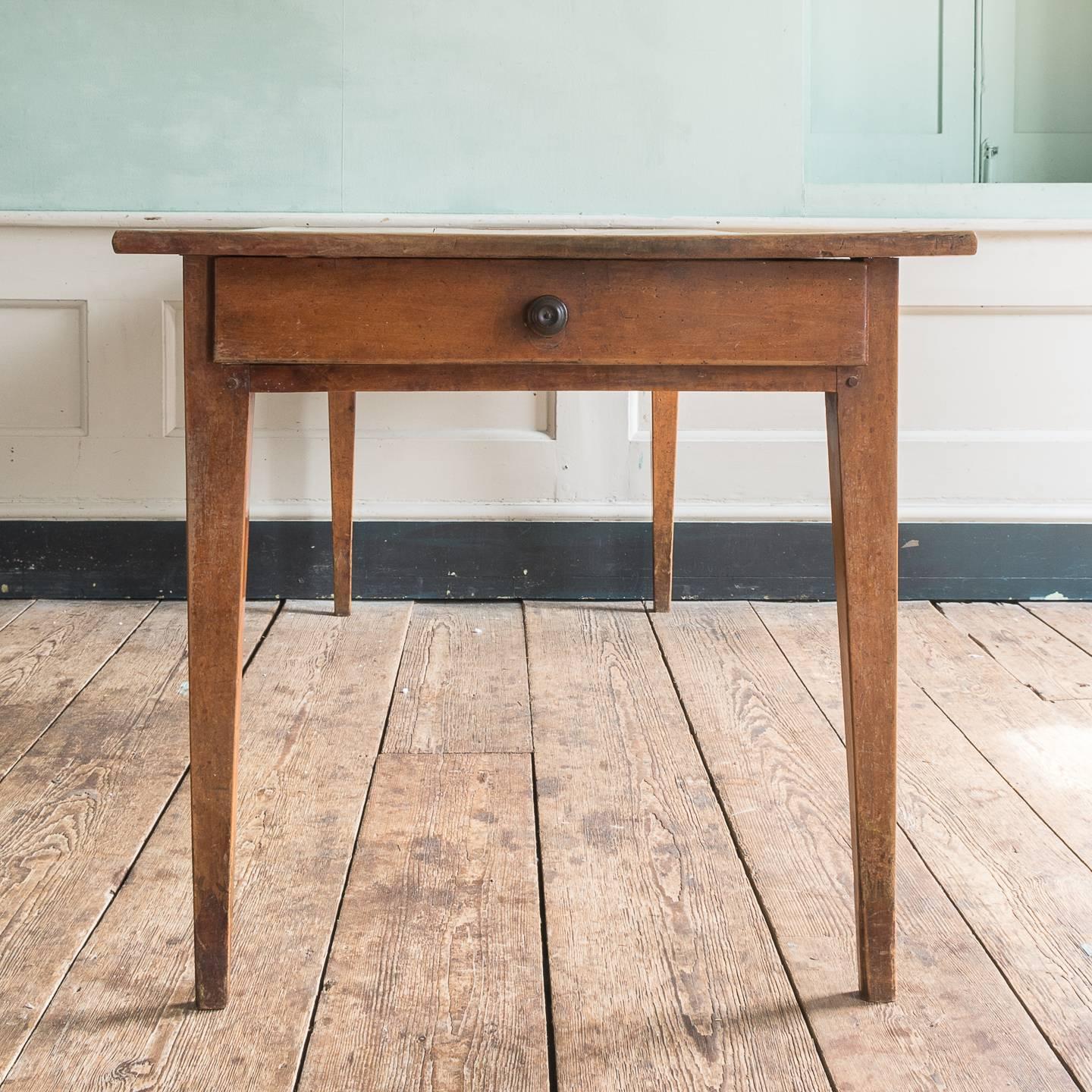 A 19th century French cherrywood farmhouse table, the cleated top above two apron drawers, on tapered legs.

This style of farmhouse table is ubiquitous in France. A classic and simple form of construction and design, often with two drawers (one at