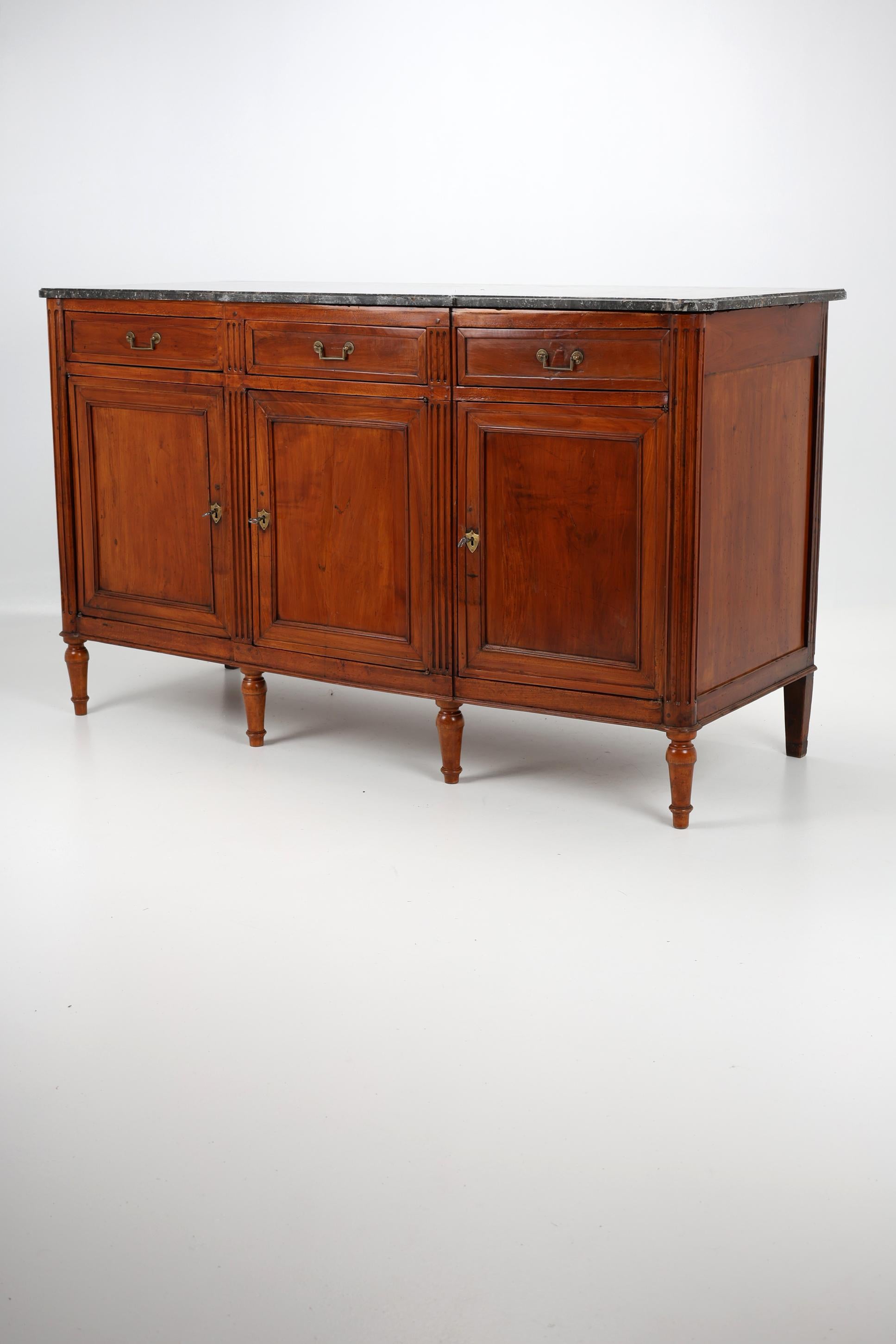19th Century French Sideboard 
1815, France
Cherrywood

Early 19th Century Sideboard made of solid cherrywood and partly construction made of solid oak wood raised on turned toupie feet. This piece has classic Louis XVI fluted corners and columns.