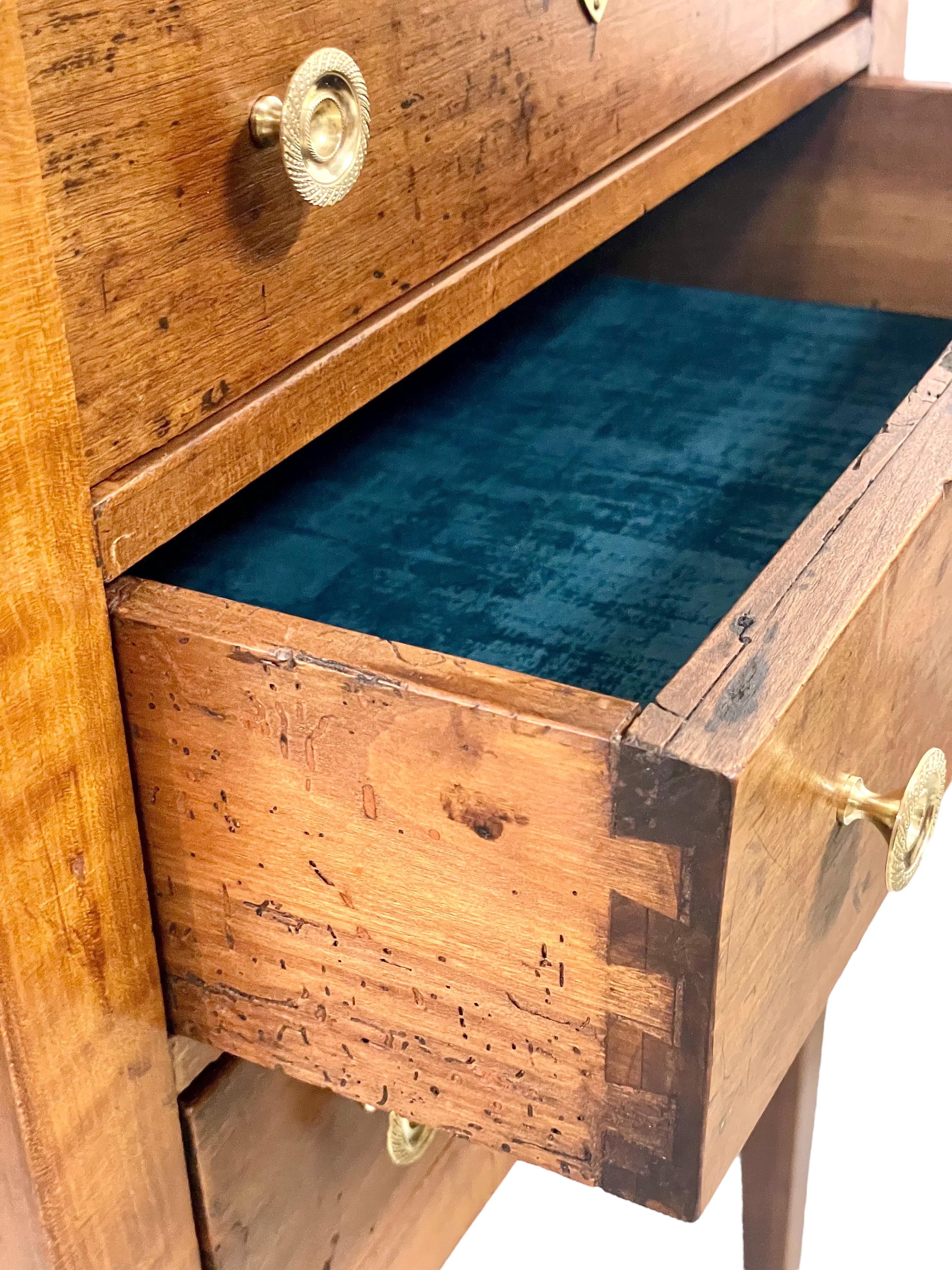 Diese charmante und zierliche Kommode aus Nussbaumholz stammt aus dem 19. Jahrhundert und verfügt über drei identisch zu öffnende Schubladen, die jeweils mit Schwalbenschwänzen versehen und mit Samt ausgekleidet sind, sowie über zwei verschnörkelte