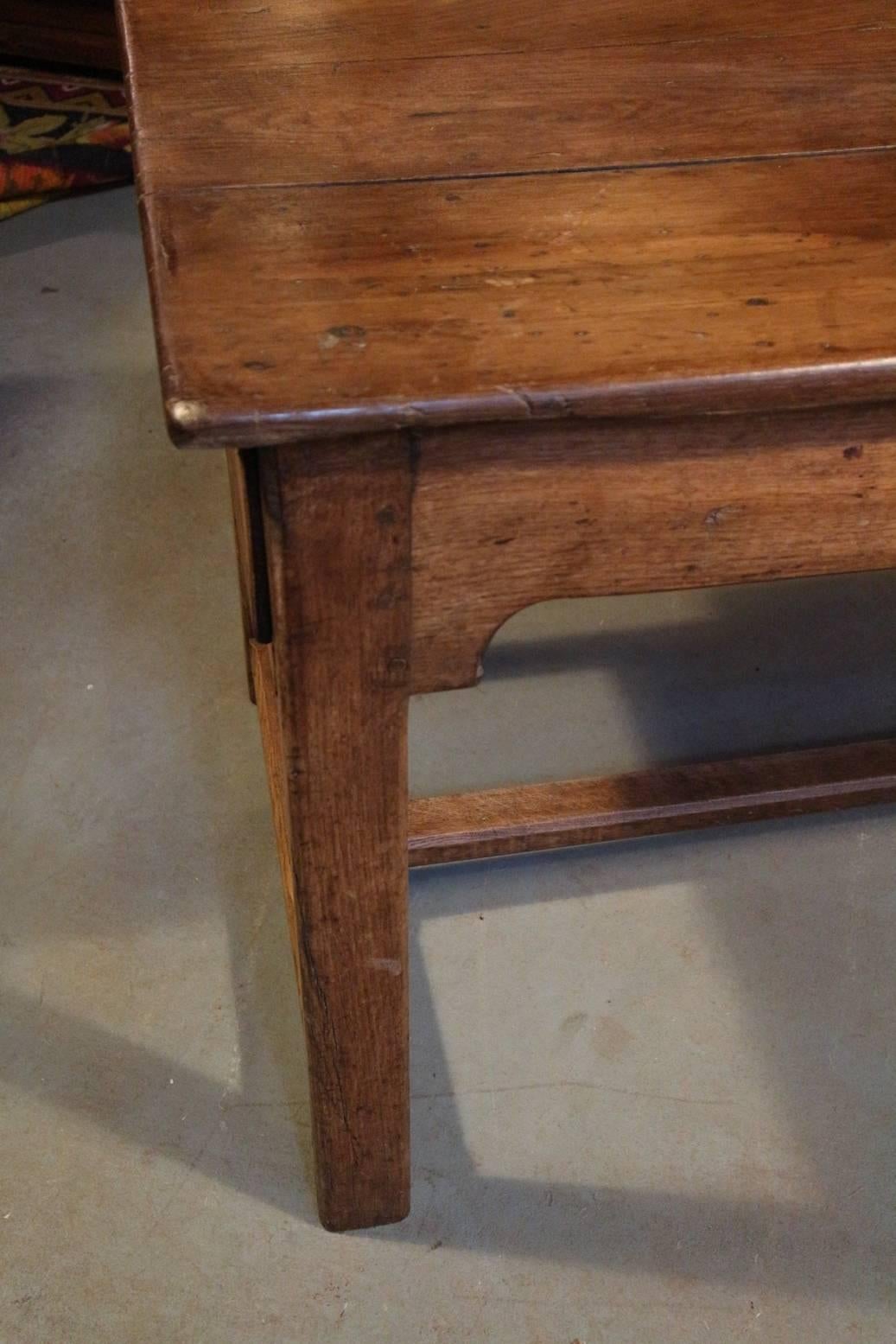 Beautiful weathered French chestnut dining room table. A long time ago the table has been adjusted to get more leg room. As a result, the drawers on the end faces are dummies. There is one small drawer in the middle. Table is in original unrestored