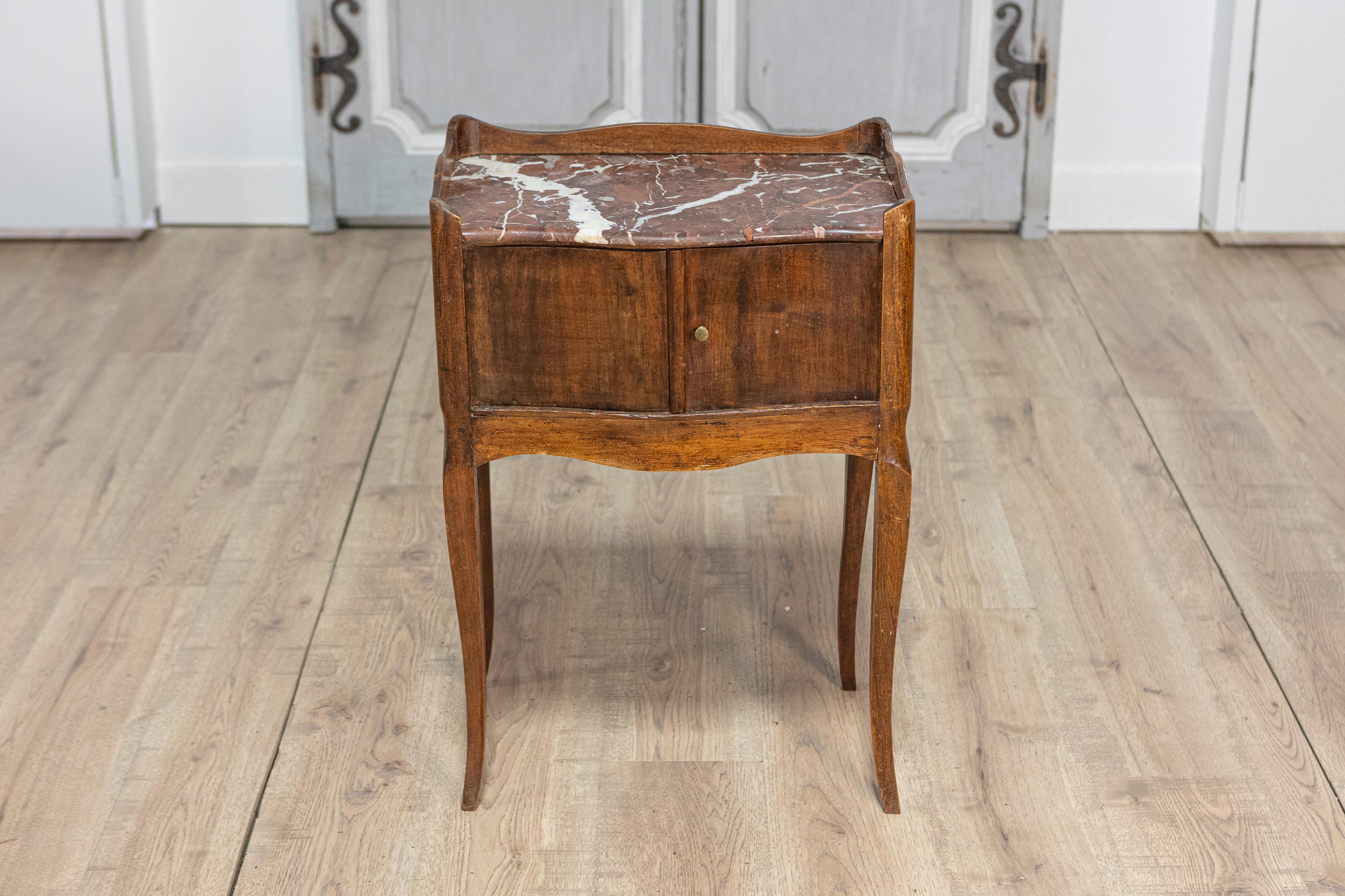 Esta mesa chevet francesa del siglo XIX es un encantador ejemplo de la fina artesanía y el elegante diseño de la época. Fabricada principalmente con madera de nogal, la mesa desprende calidez y sofisticación, y muestra la belleza natural de las