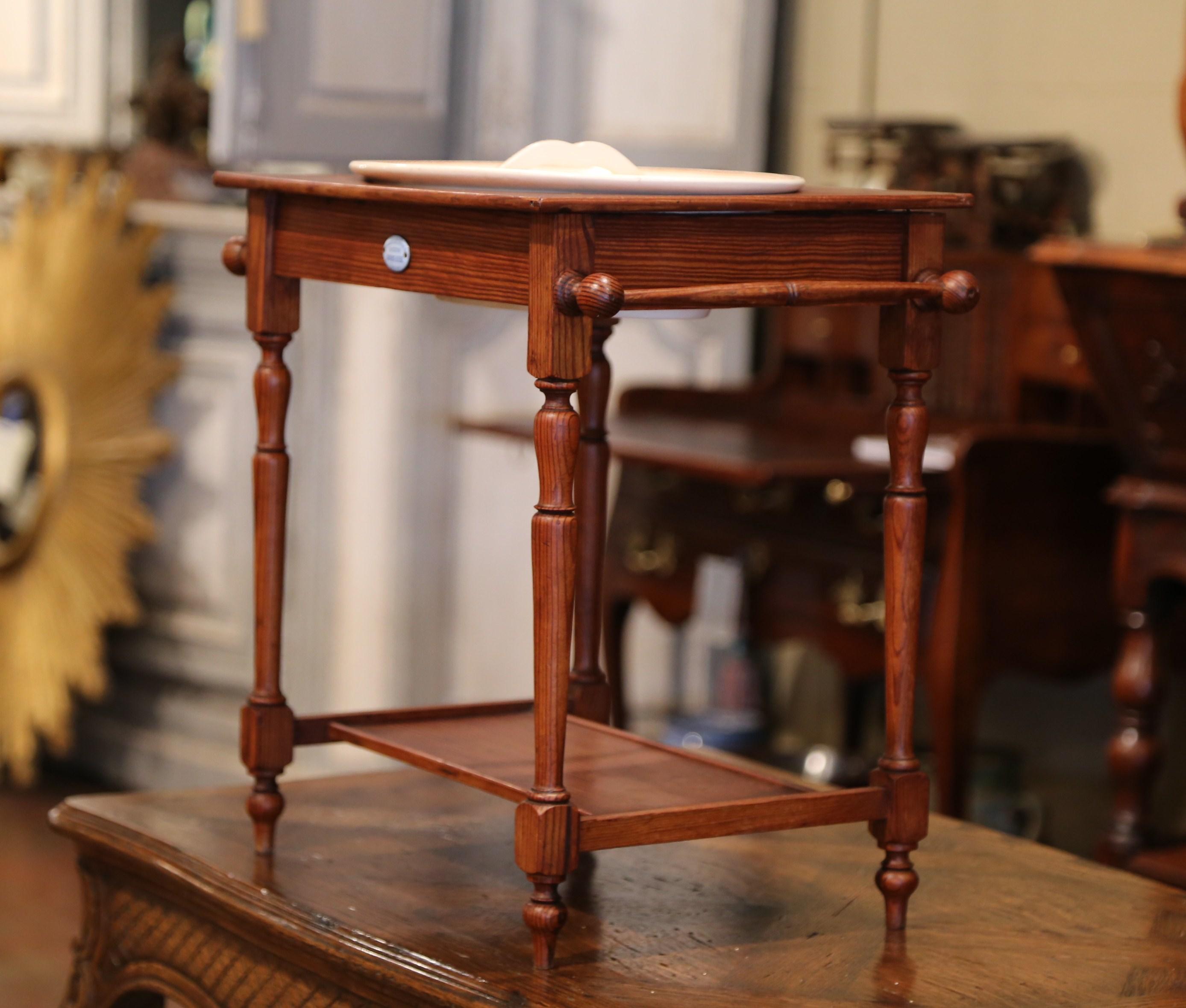 Decorate a little girl's room with this antique washstand and lavabo. Crafted in France circa 1880, the pine table has side handles and sits on four turned legs with a stretcher and bottom shelf. The wash Stand features its original porcelain basin