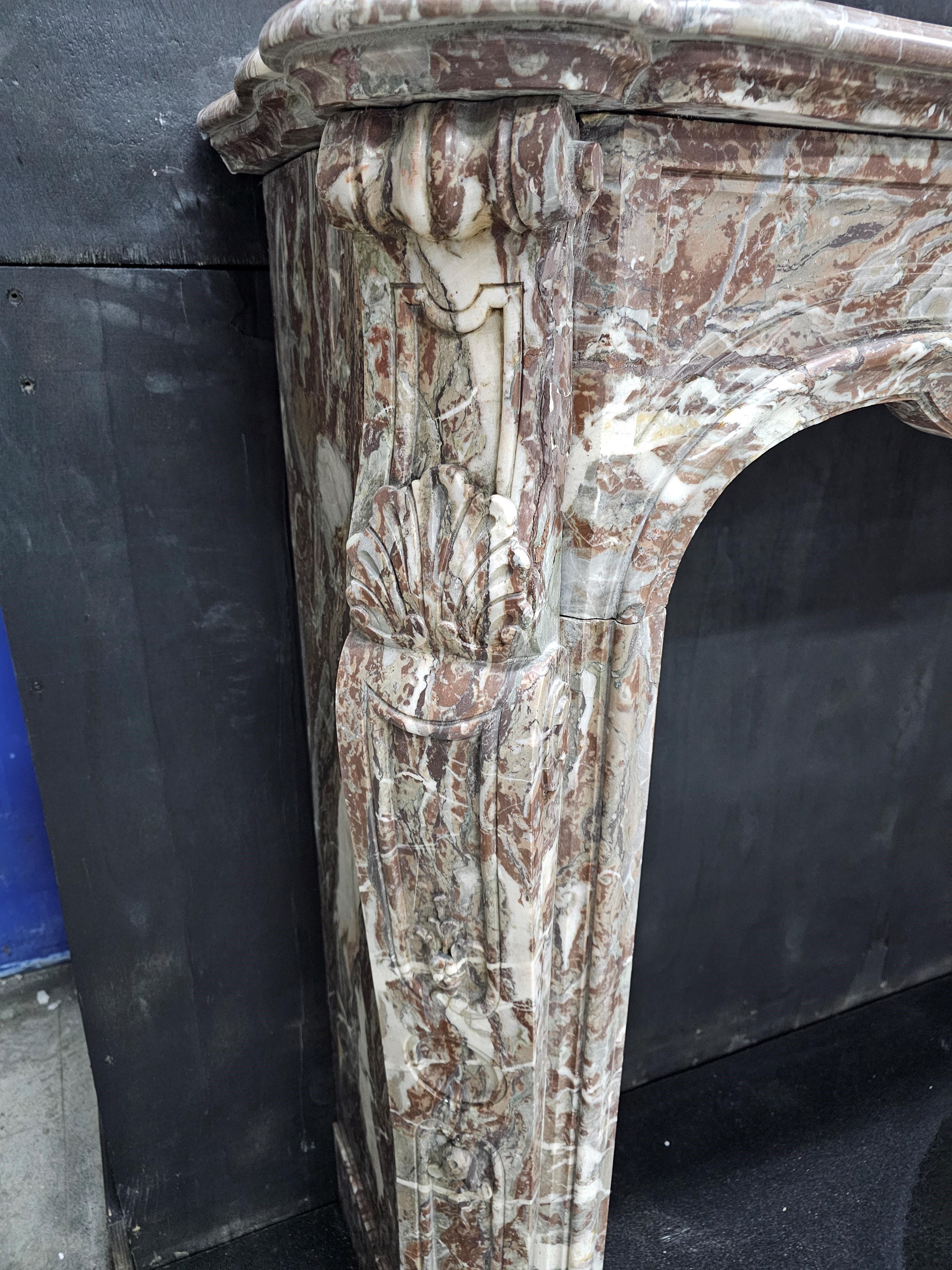 Cheminée française du XIXe siècle sculptée en Arabescato Orobico Rosso dans le style Louis XV, avec une frise serpentine présentant un cartouche central sculpté et des jambages sculptés en biais.

Encombrement : 67 