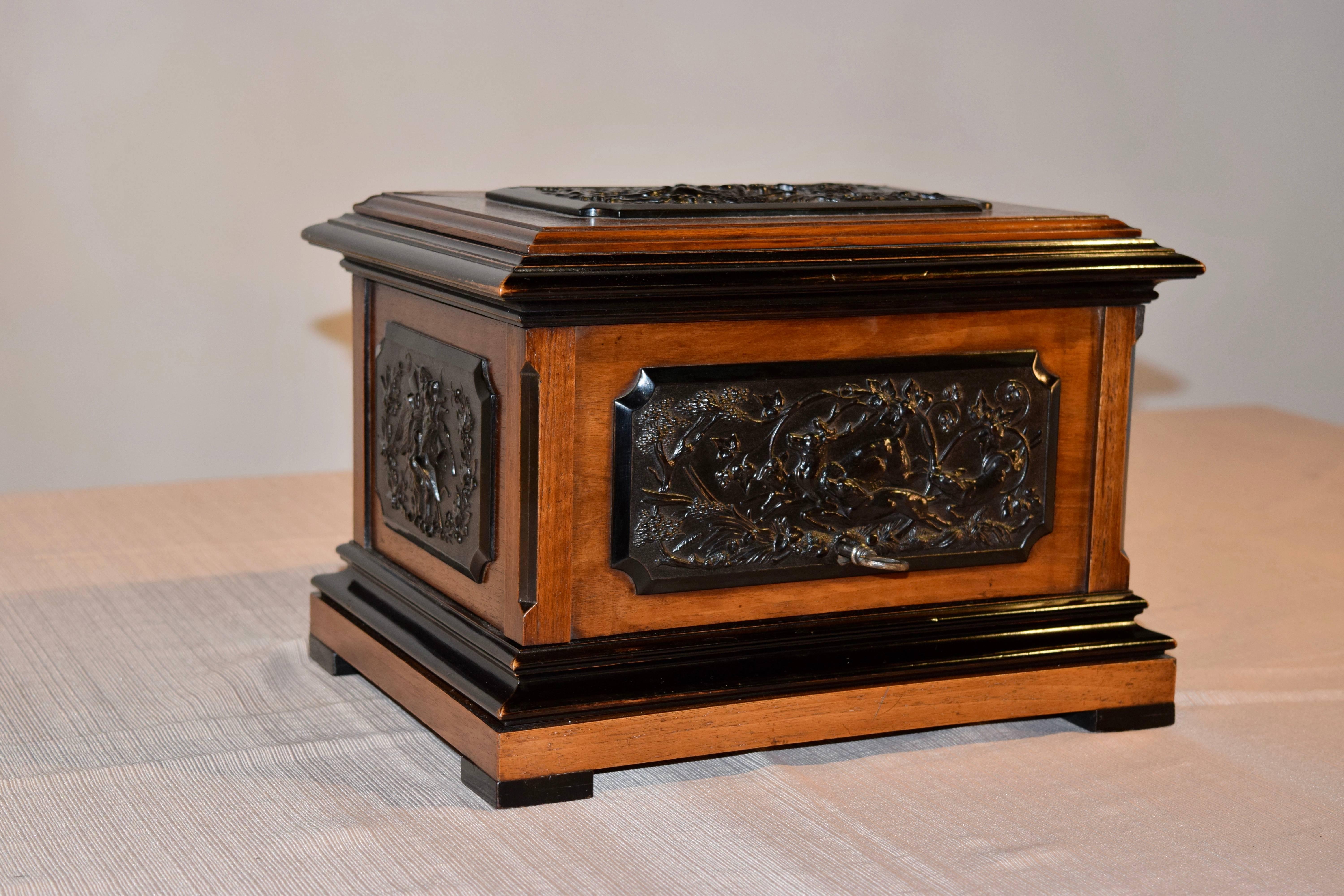 19th century mahogany cigar humidor from France. The top has a raised central plateau with a highly molded edge, which is ebonized for contrast. The top and sides have applied plaques in gutta percha depicting hunting scenes, which are in excellent