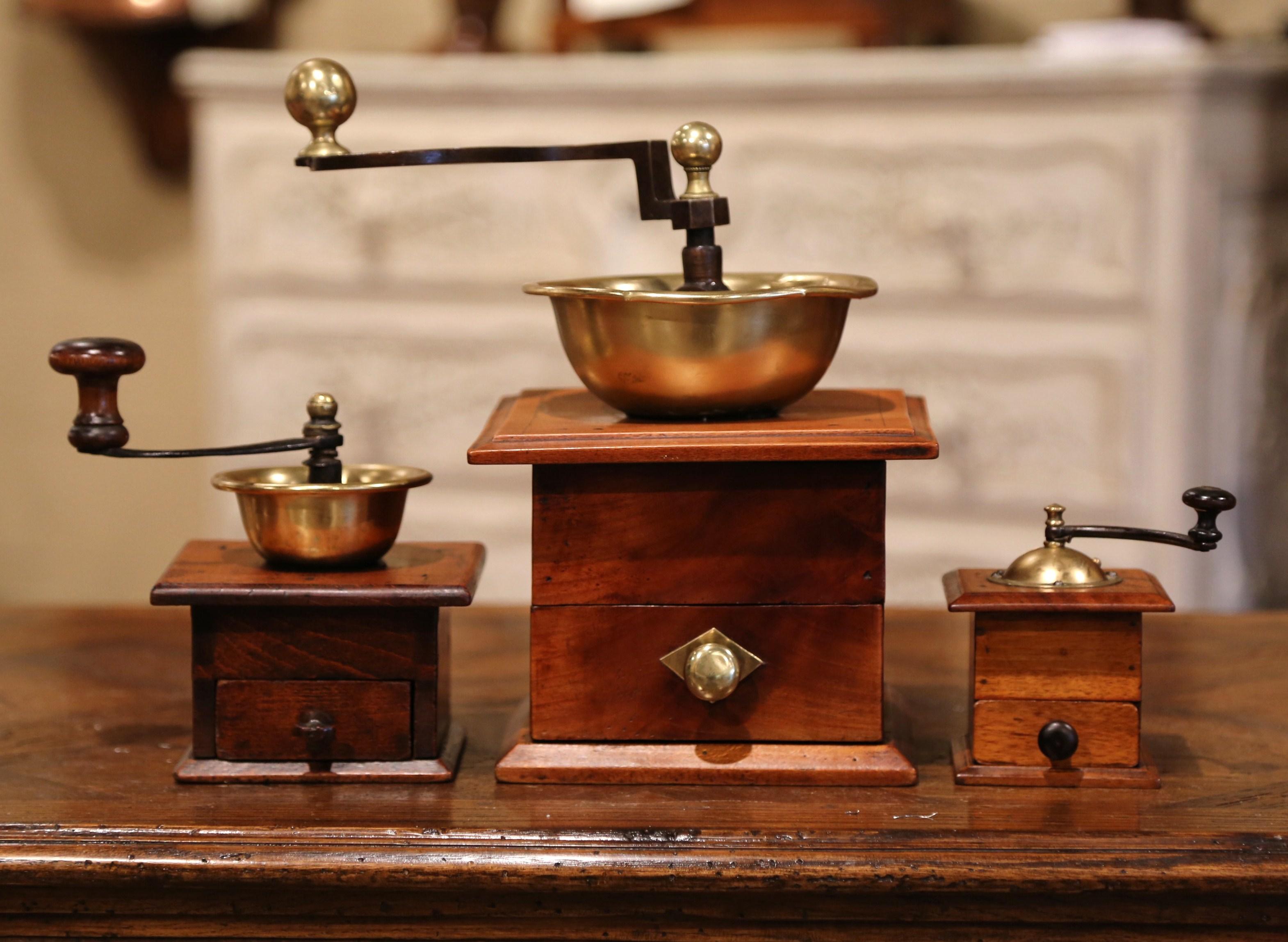 Decorate a country French kitchen with this antique coffee grinders set collection in graduated sizes. Crafted in France circa 1880 and made of walnut, iron and brass, all grinders are in excellent working condition with a rich patinated finish.