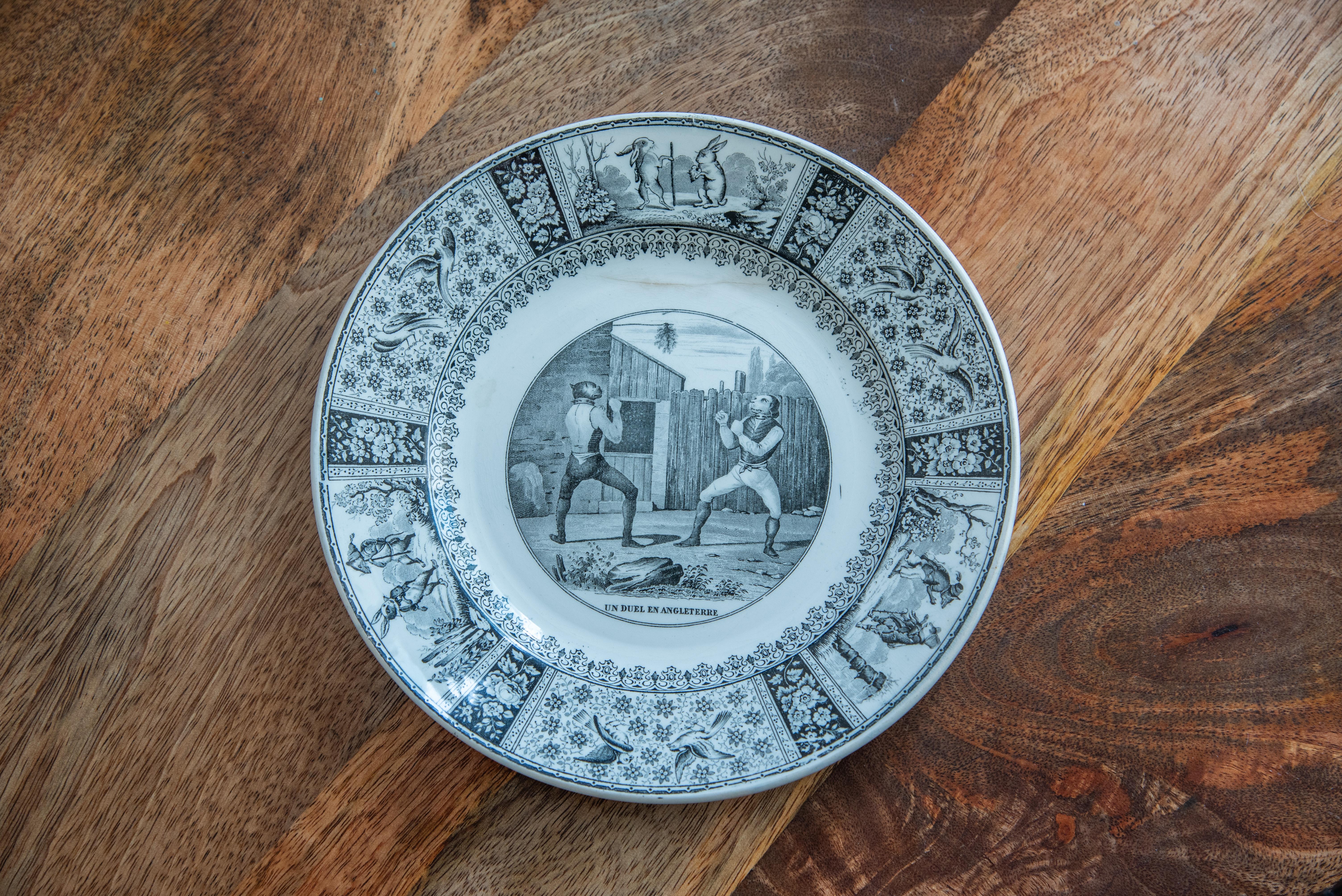 Step into the enchanting world of 19th Century French Comique Plates by Creil et Montereau, a captivating set of four distinct black and white plates that embody humor and charm. Each plate is a delightful work of art, showcasing comical scenes that