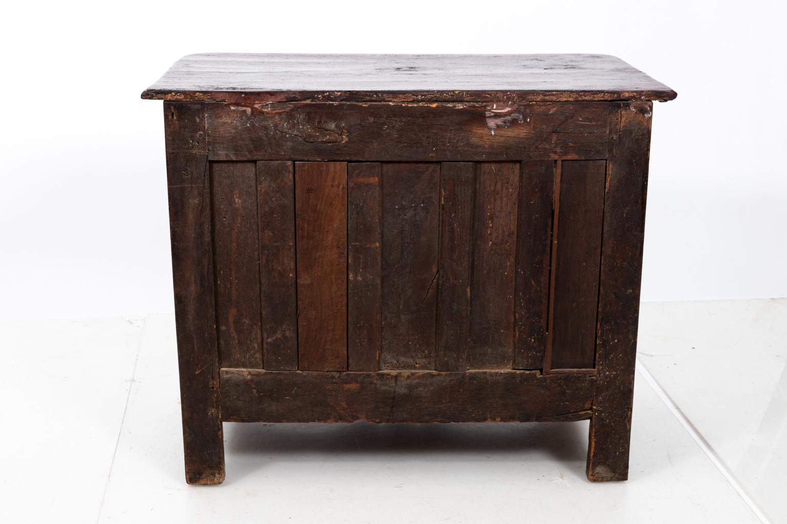 French walnut commode with four drawers, bronze hardware, and carved detail, circa 1830s. Please note of wear consistent with age including old repairs and discoloration.