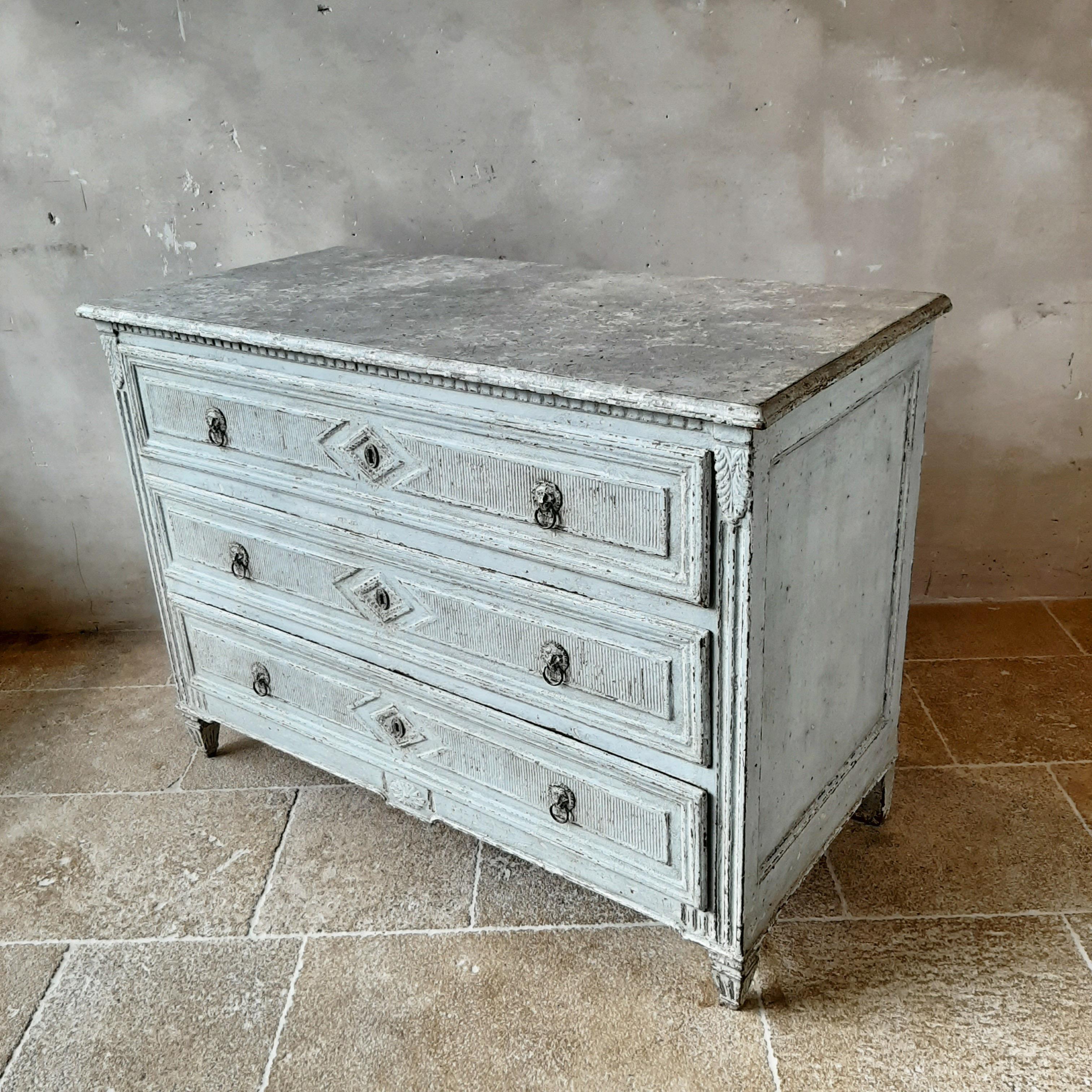 Antique commode from 19th century France. This beautiful chest of drawers has an oakwood exterior that has been patinated in an aged grey with a marbelised top and with the stunning details on the drawers and legs, this Louis XVI style commode will