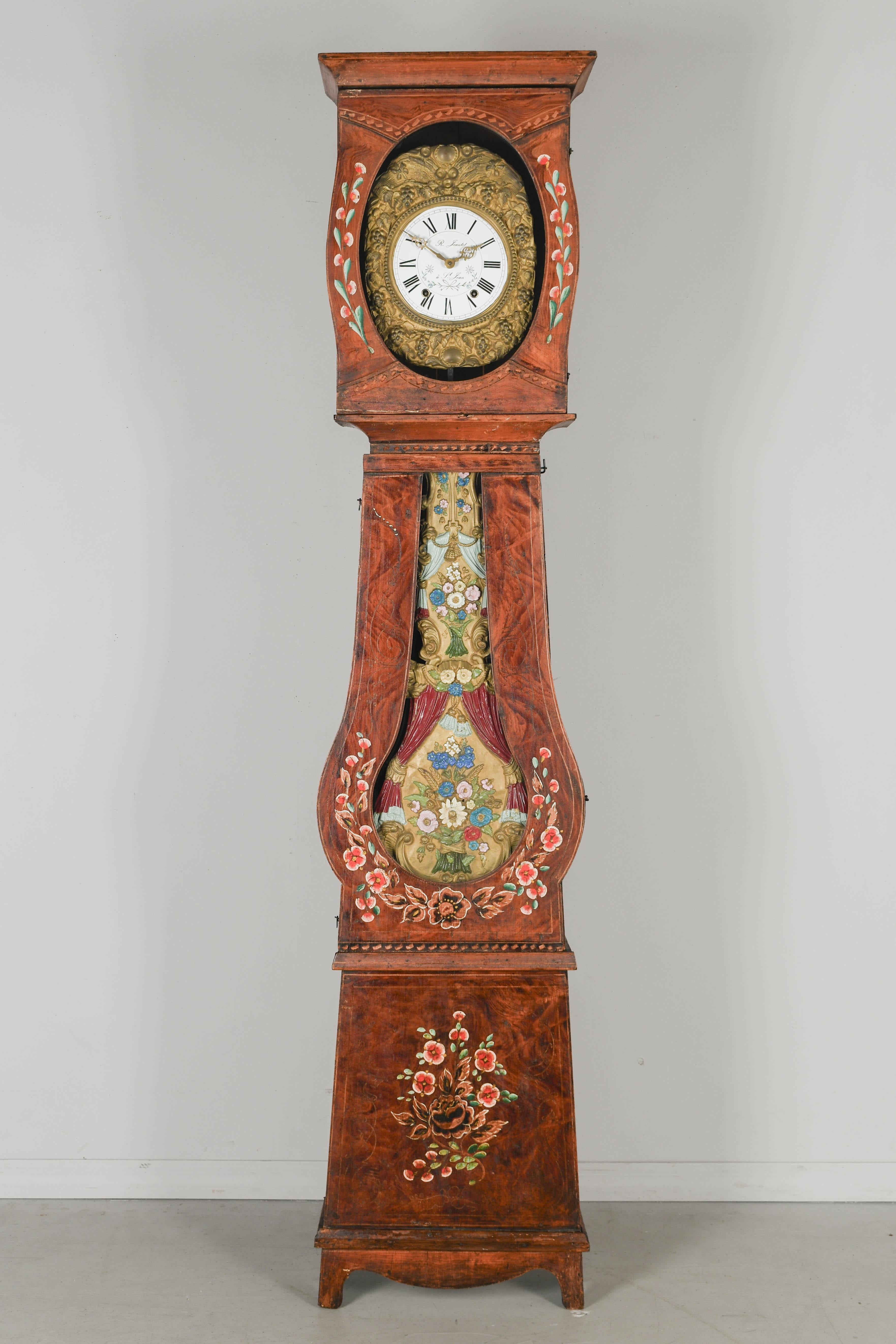 A 19th century Country French comtoise, or grandfather clock, with polychrome painted pine case and embossed brass pendulum. Seven day Morbier movement, professionally cleaned and in working order. New enamel face signed by the clockmaker, R.