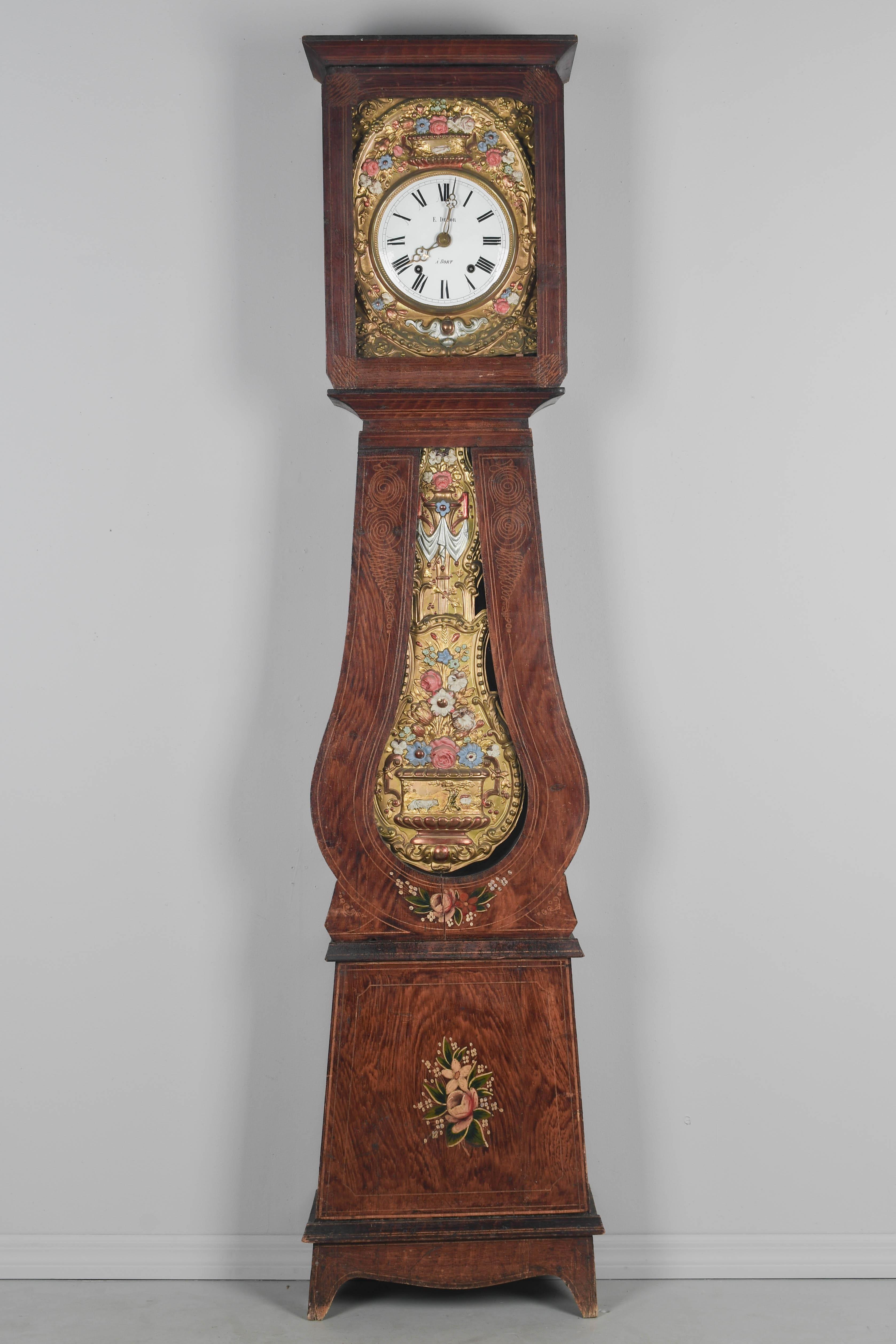 A 19th century Country French comtoise, or grandfather clock, with polychrome painted pine case and embossed brass pendulum. Seven day Morbier movement, professionally cleaned and in working order. New enamel face signed by the clockmaker, E. Delor