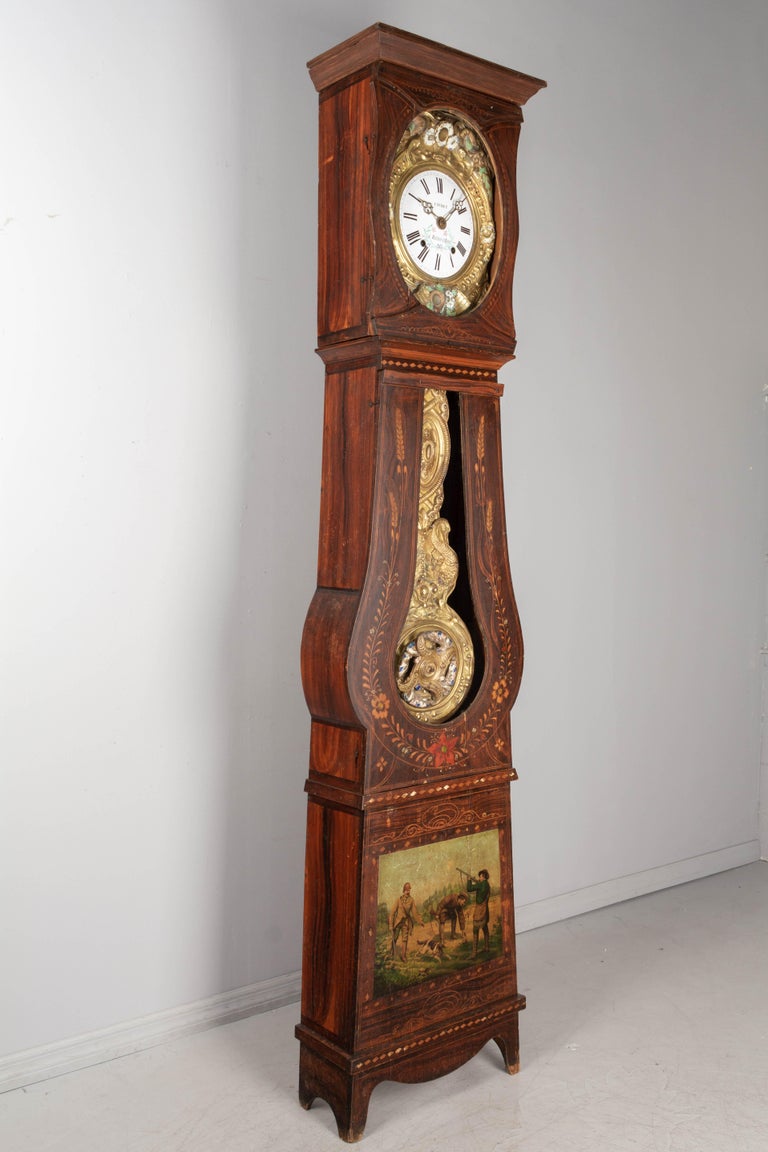 A French Country comtoise, or grandfather clock, with polychrome painted pine case and embossed brass pendulum. Original seven day Morbier movement, professionally cleaned and in working order, having an enamel face signed by the clockmaker, Caubet