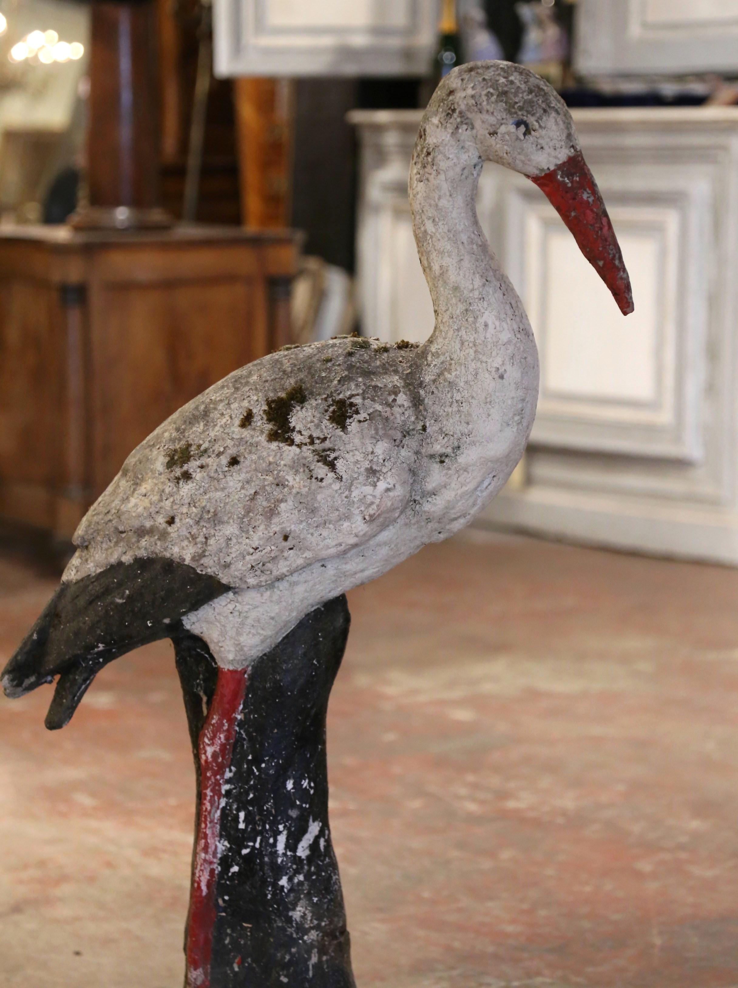 Decorate a garden or courtyard with this large heavy antique crane sculpture! Crafted in Normandy France circa 1870, and built of concrete, the bird stands on a round base with grass-like mound. The body of the crane is supported with straight legs