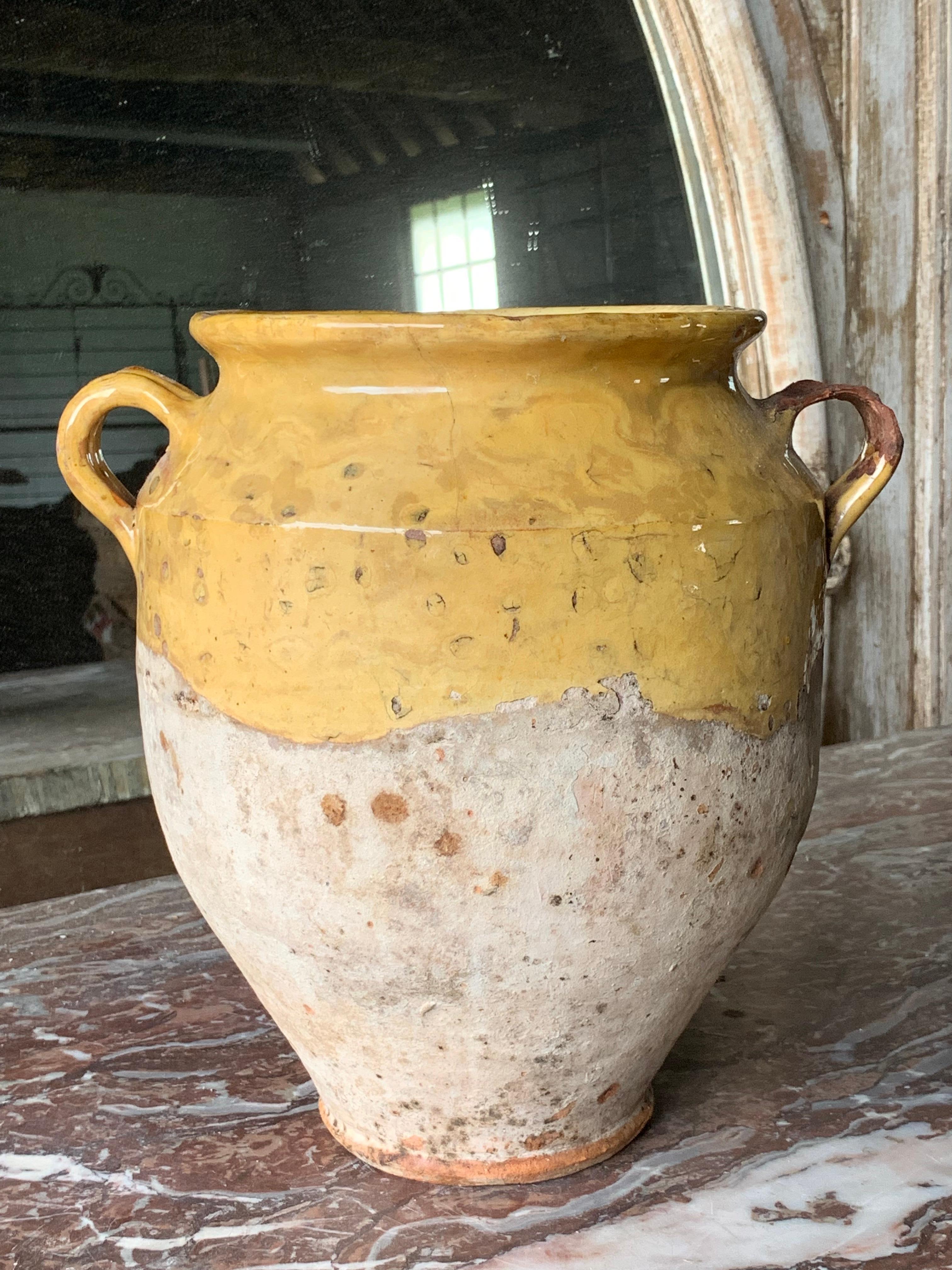 Un bel vaso da confit francese del XIX secolo con una bella smaltatura colorata. Un manico presenta segni di usura e di restauro (vedi foto). C'è anche una piccola crepa che si può vedere nelle foto, ma è solida e stabile, quindi è solo