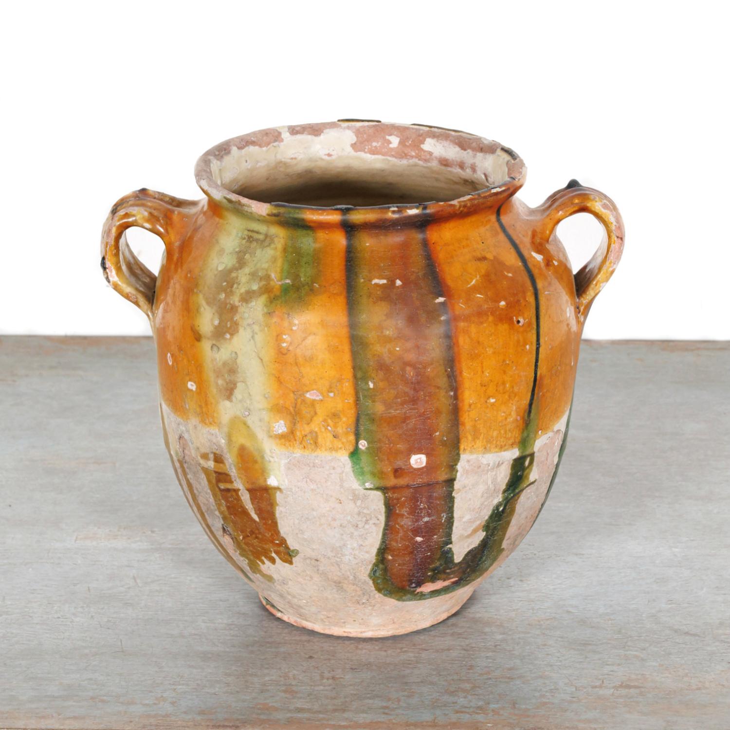 A colorful 19th century French pot de confit or confit pot from southwest France having two handles and a yellow ochre glaze with green and caramel drips, circa 1870s. Utilitarian earthenware vessels like this were once a staple in French kitchens,