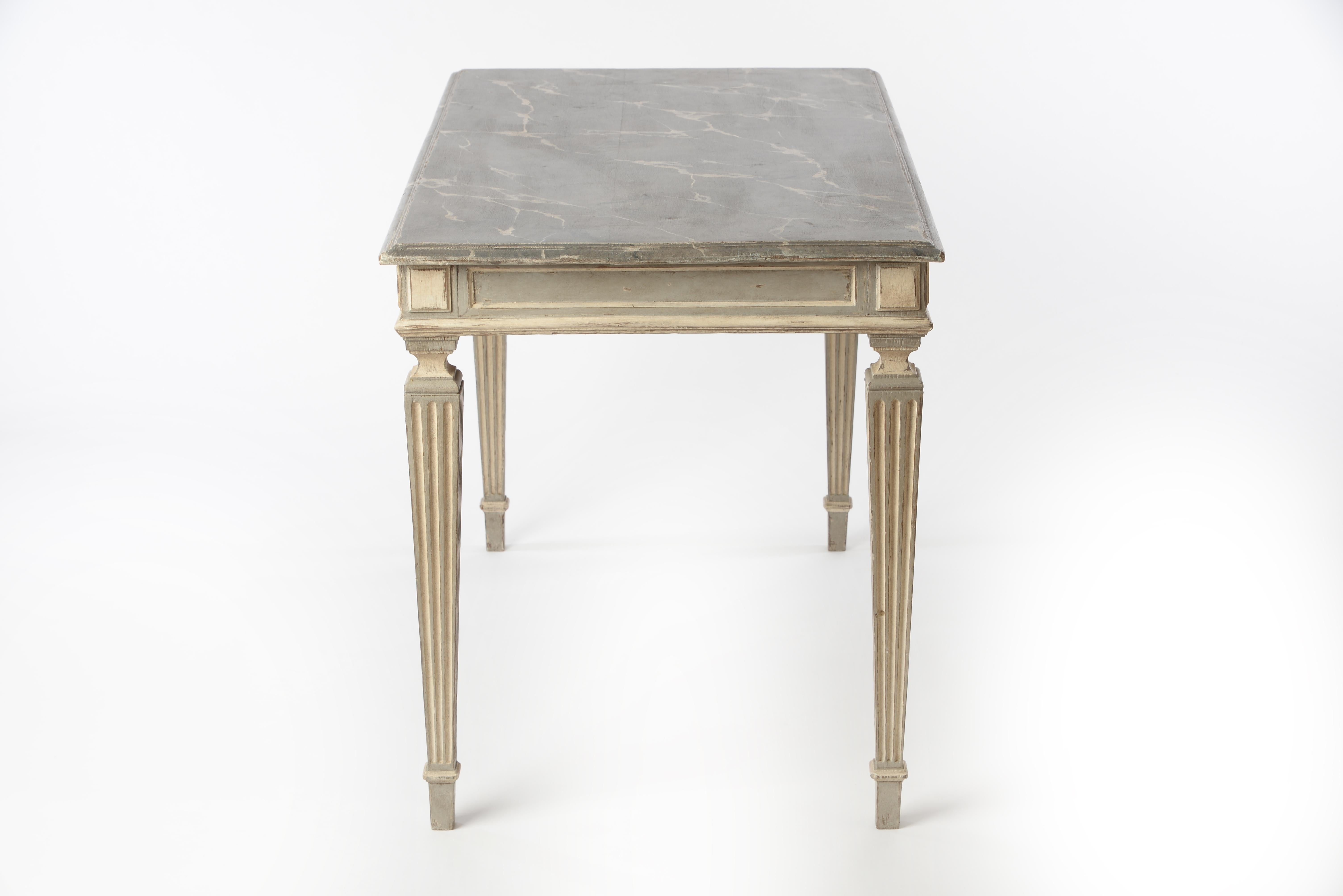This gorgeous French console table in the style of Louis XVI comes with a beautifully marbled table top and carved legs. Very elegant table that could even be used as a small dining table due to its larger size. New paint.