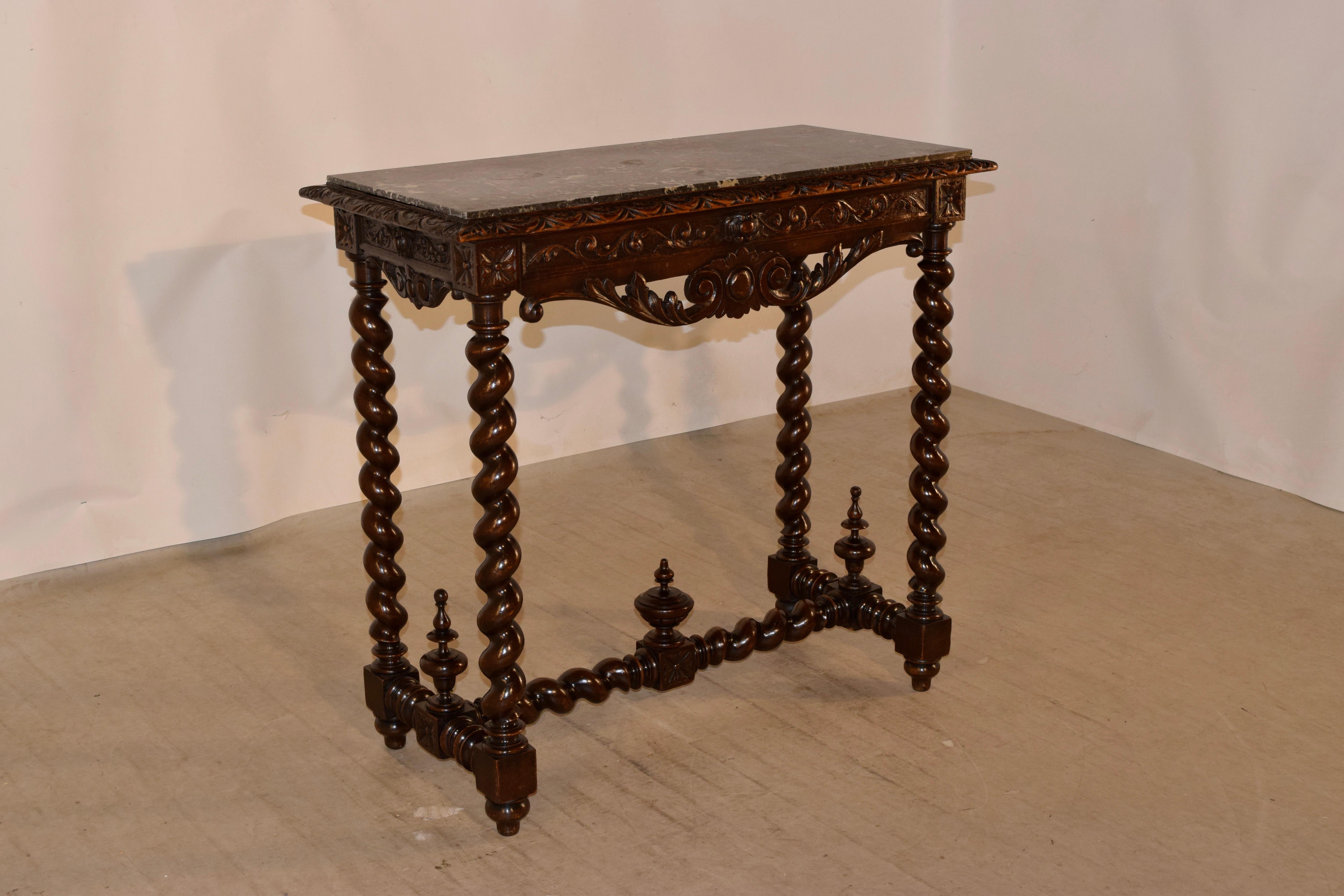 19th century French marble topped console table made from walnut. The top is black marble, which is removable and rests upon a solid walnut base. The table base is wonderfully hand carved decorated on the beveled edge around the top and the apron as