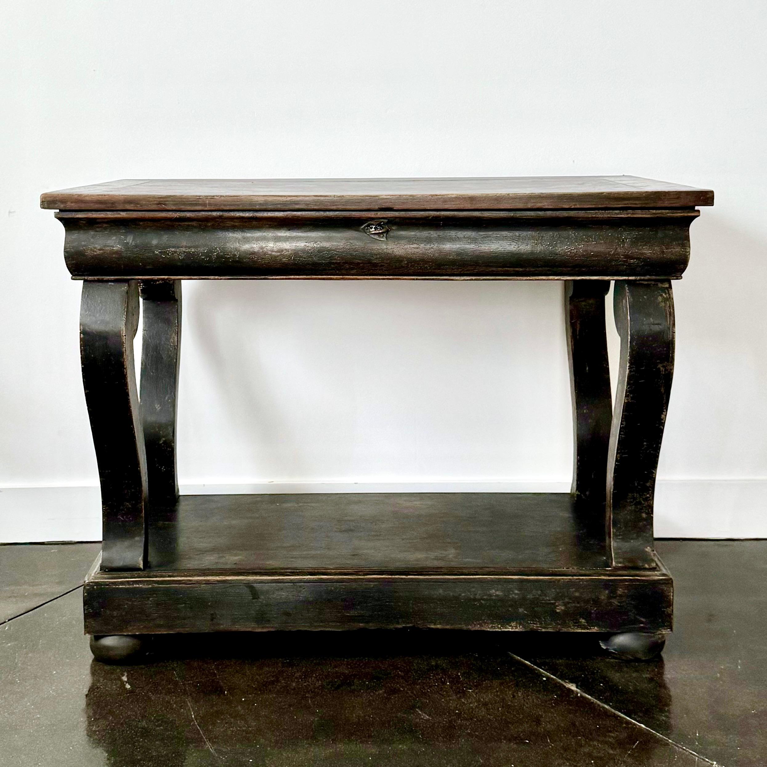 Elegant antique console, crafted in France 19th century.
The console stands on four cabriole legs with a lower shelf for display. The serpentine front apron with one lockable drawer.
The piece stands on later replaced ball feet.