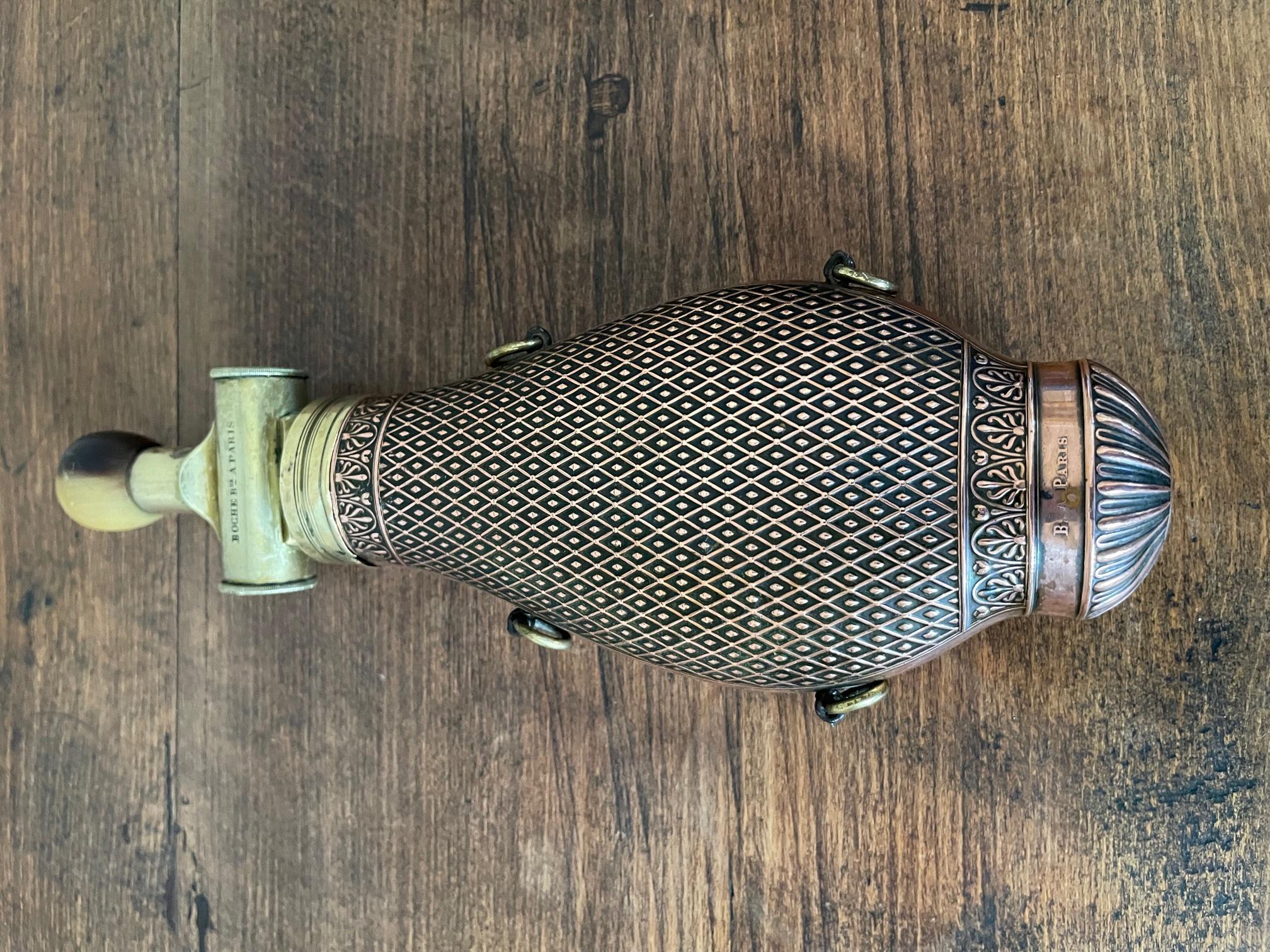 Very original 19th century French copper and brass military powder flask patented by Boche in Paris (signature on the plug and also on the base). 
The top of the plug is made with horn. Grid details on the copper. 
Two rings on each side. Three