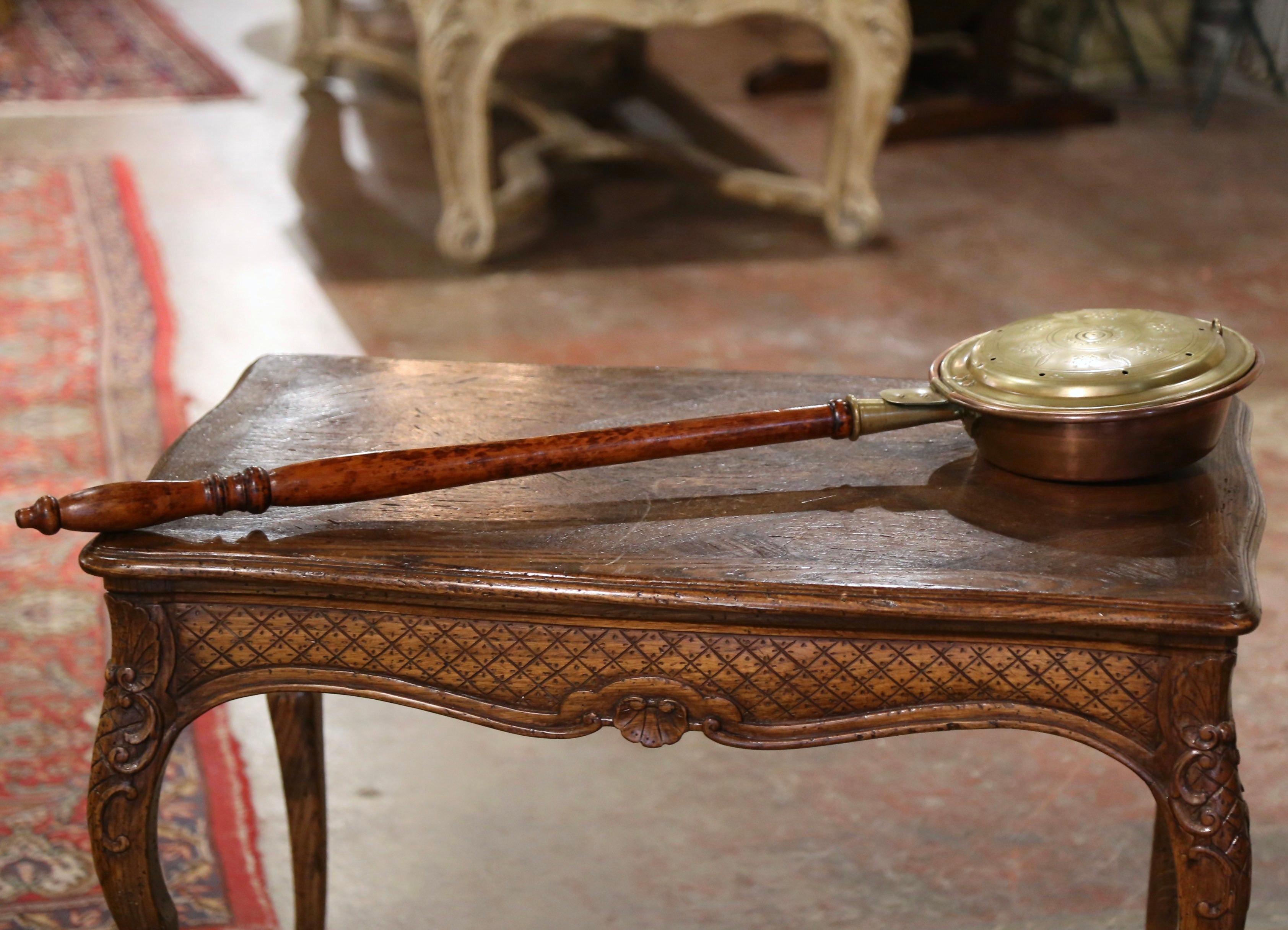 Dekorieren Sie eine Küchenwand mit diesem französischen Kupfer-Bassinoire oder Bettwärmer. Das um 1880 in Frankreich gefertigte Stück ist mit einem Holzgriff versehen und besteht aus einem kupfernen Gefäß mit Deckel; der Deckel mit Blumen- und