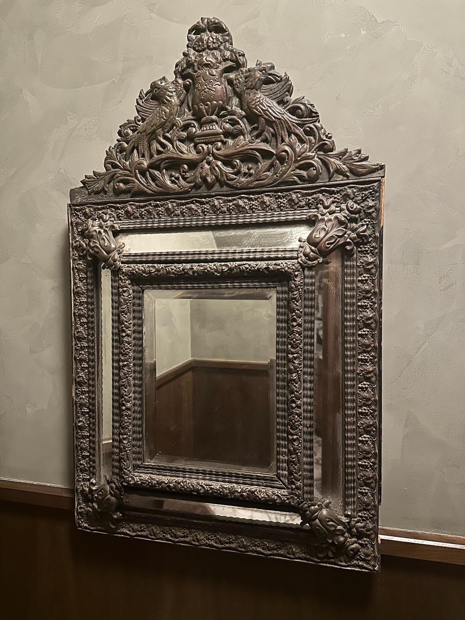 Late 19th-century French mirror. The frame of the mirror is decorated with flowers and shells pressed into sheet copper. The back of the mirror is supported with wood. Featuring one main mirror bordered by narrow mirror insets above, below, and at