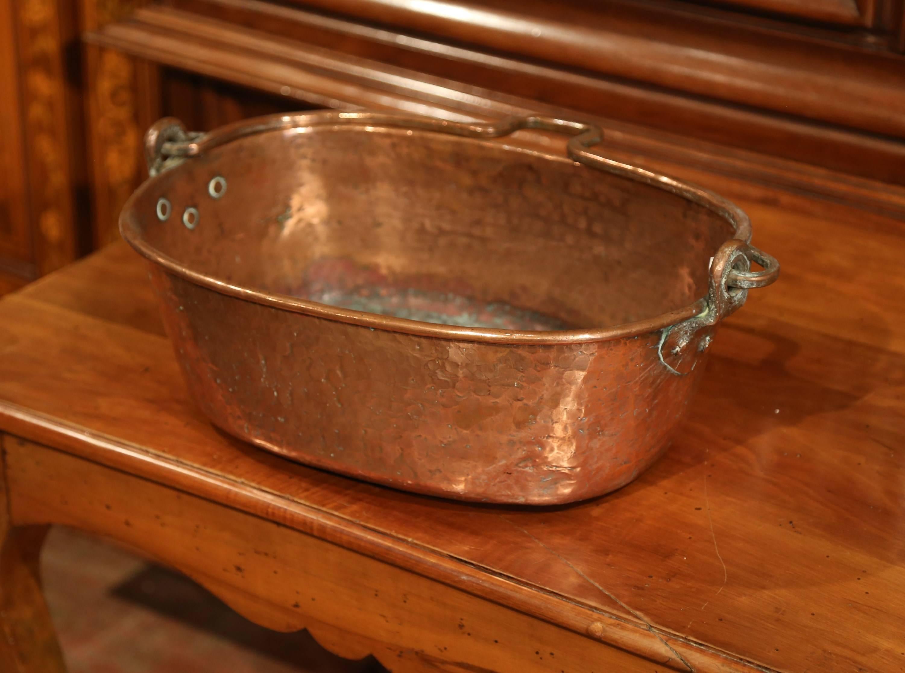 Large antique marmelade bowl from Normandy, France, crafted circa 1860, the oblong “bassine a confiture” features a forged brass handle attached with rivets. The kitchen piece is in excellent condition with rich patinated finish, and could also be