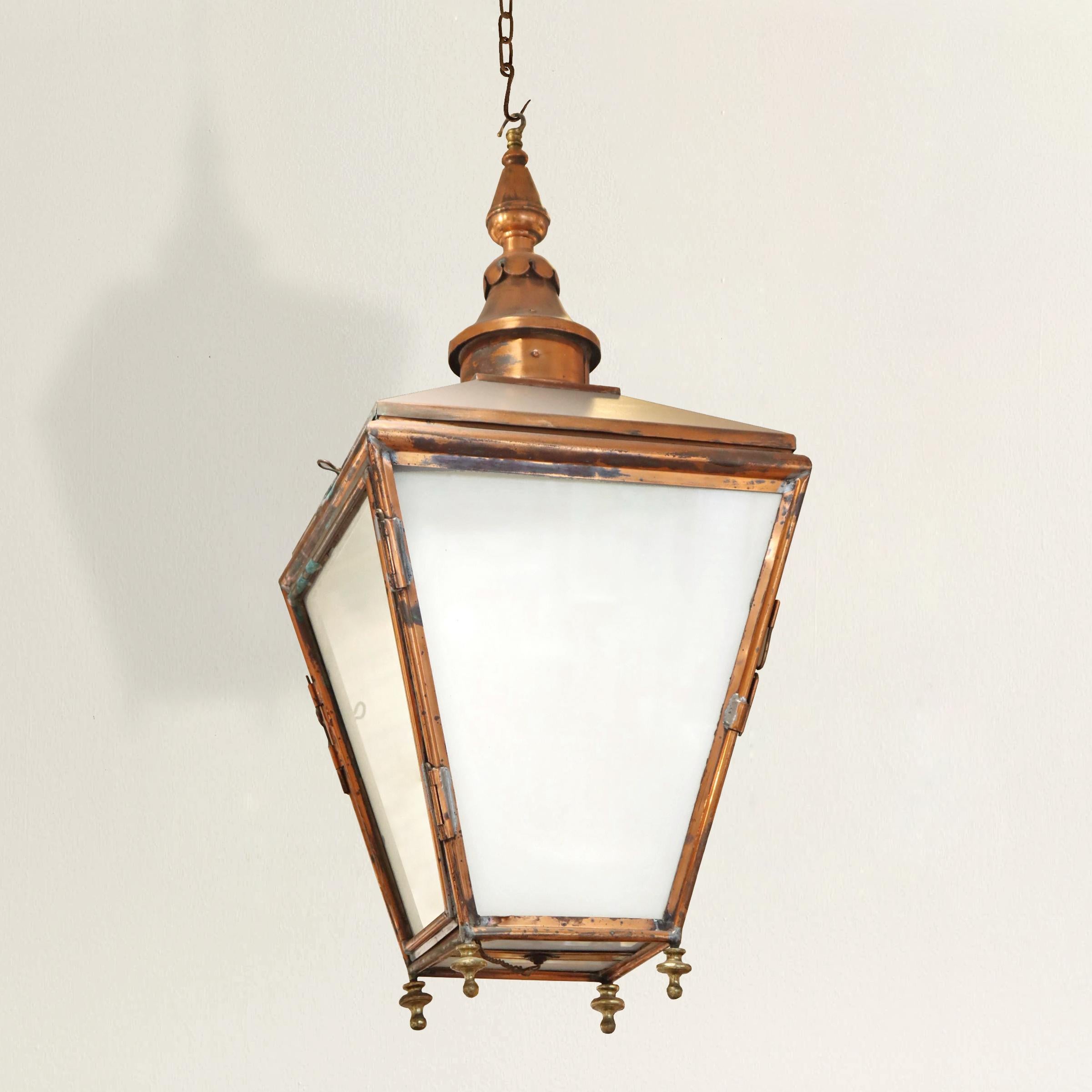 A charming 19th century French copper lantern with tapered side with milk glass, two of which open up, a turned finial top, and turned brass finials on the bottom. Electrified for US; requires a single medium base bulb. No canopy.