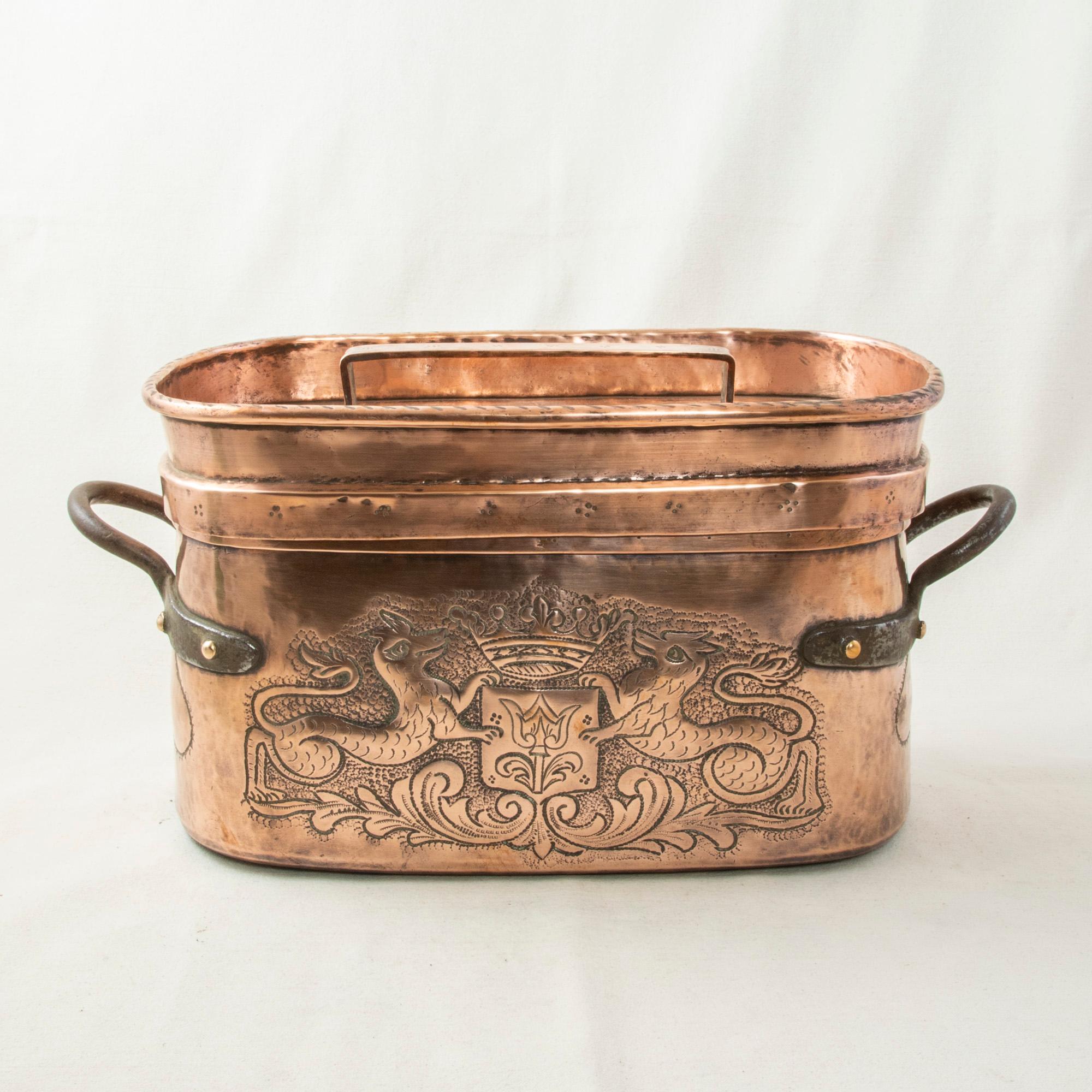 Originally used in a chateau, this mid-nineteenth century French copper repousse braising pot with lid is called a daubiere in French. This piece features a hand hammered repousse coat of arms on one side flanked by lions with a crown above. On the
