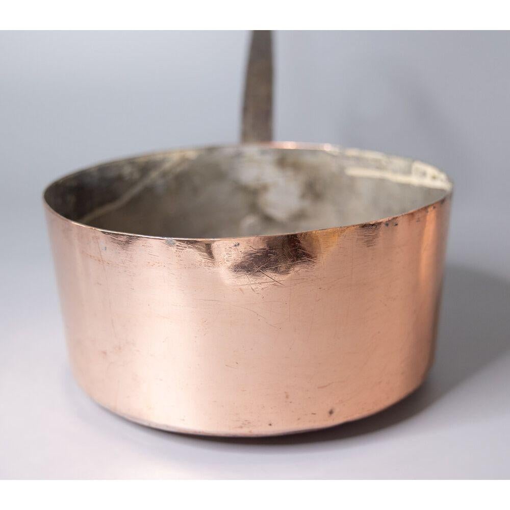 A gorgeous antique 19th-Century French hand forged copper pot or saucepan. This fine quality pot is large and heavy with a lovely long iron riveted handle and beautiful patina. Add some French country style to your kitchen decor with this fabulous