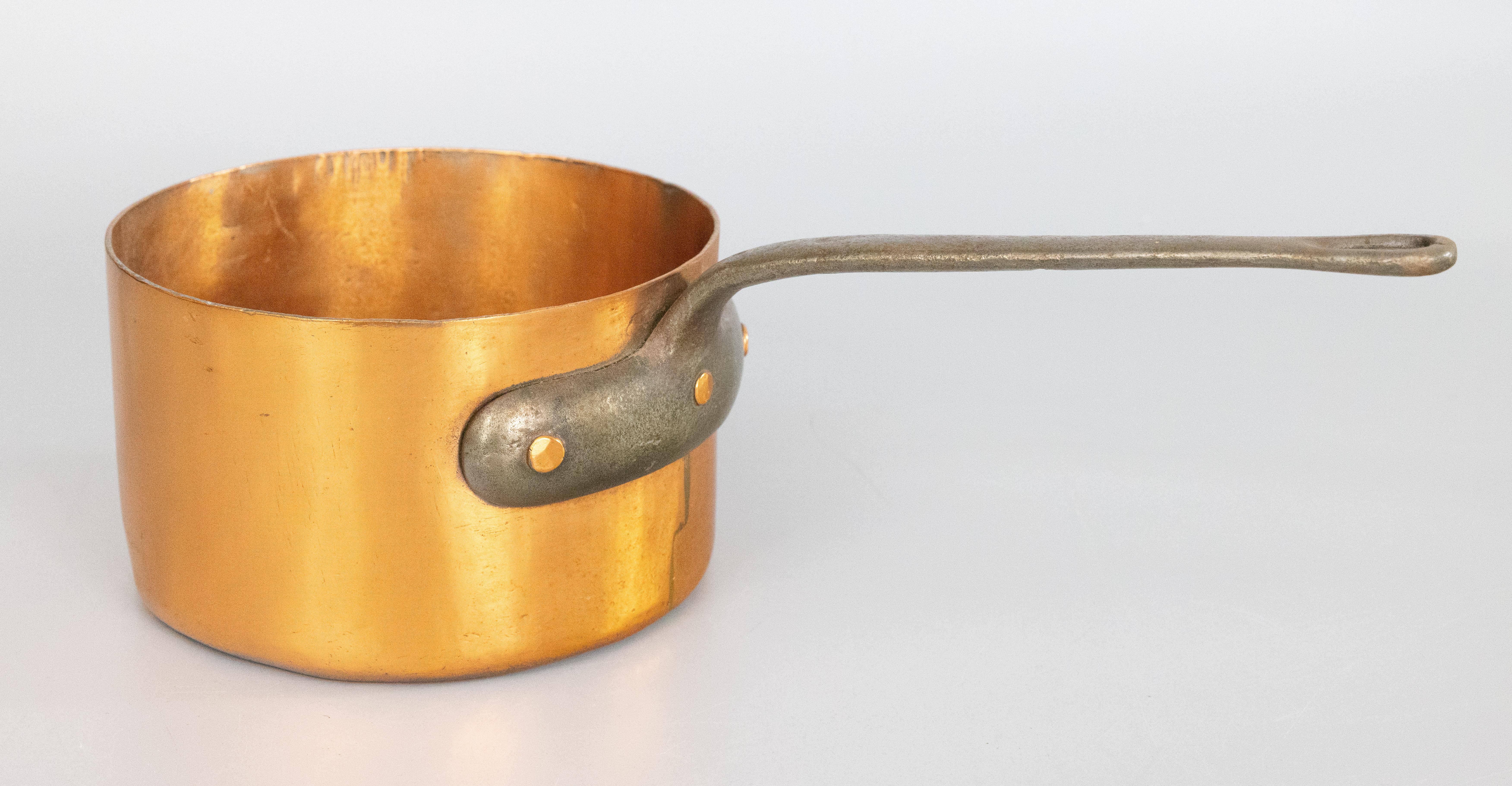 A gorgeous antique 19th-century French hand forged copper pot or saucepan. This fine quality pot is large and heavy weighing over 7 lbs with a lovely long iron riveted handle and beautiful copper patina. Add some French country style to your kitchen