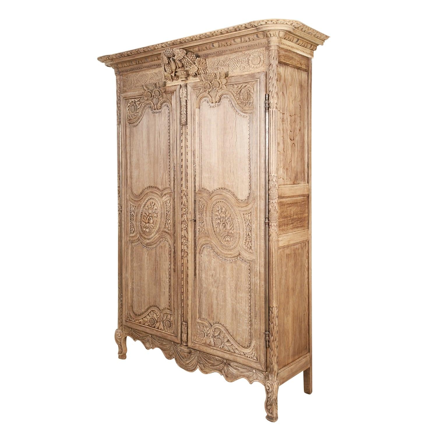 French Country Louis XV style bleached armoire de mariage, circa early 1800s, handcrafted of French oak near Saint-Lô, a commune in the Normandy region. This beautiful 19th century wedding or marriage armoire features symbolic carvings typical of