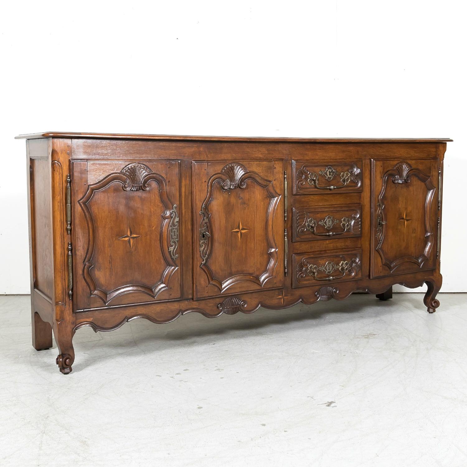 A mid-19th century French Country Louis XV style enfilade buffet handcrafted of solid oak by talented artisans near Vannes, a fortified medieval town in the Brittany region of northwest France, circa 1850s. Having a molded edge rectangular plank top