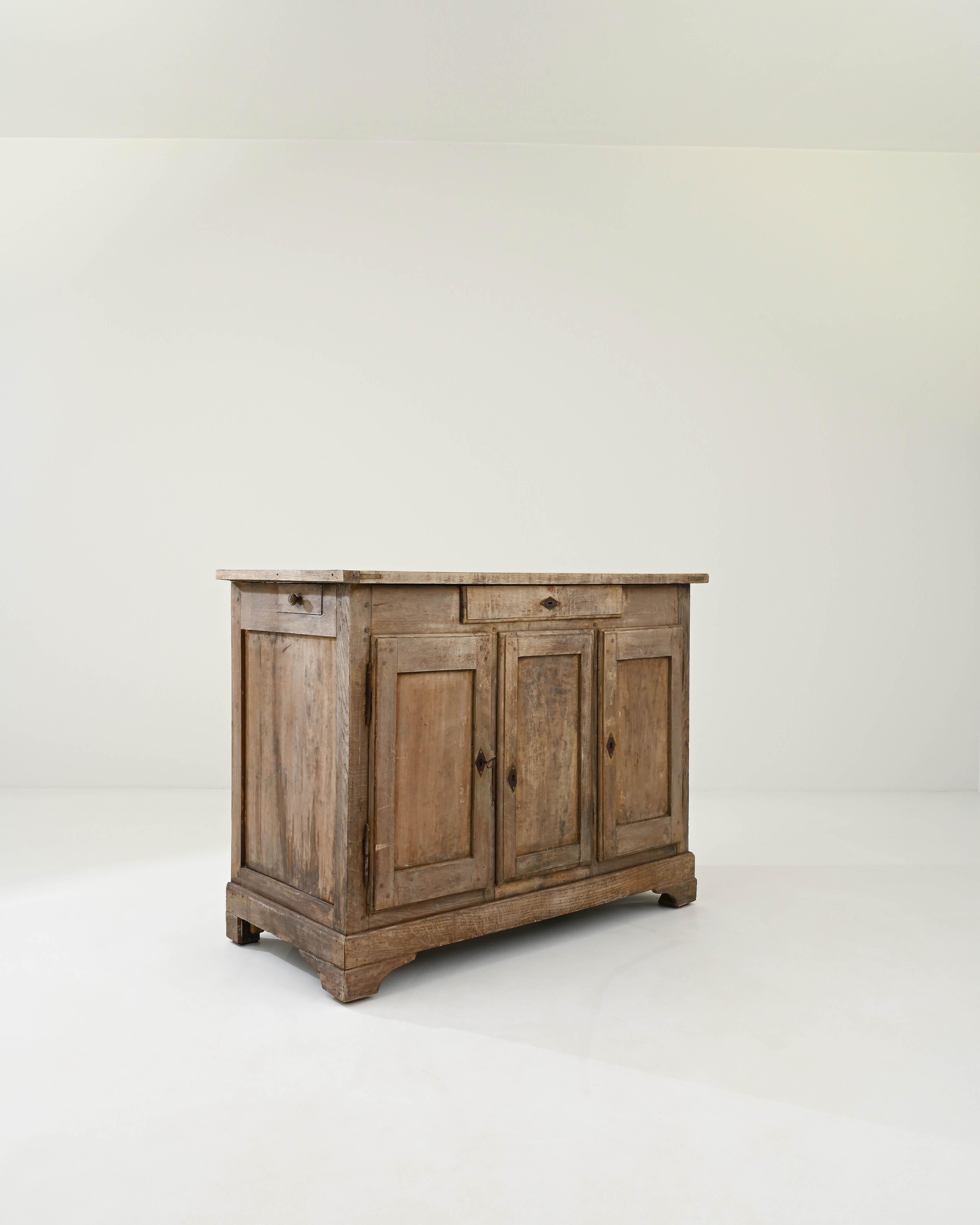 A quintessential Country French buffet cabinet, made circa 1800. The simple geometric shape recalls a countryside local and the time tested approach of regional French cabinet makers. Combining earthy colors and elevated craftsmanship, this buffet