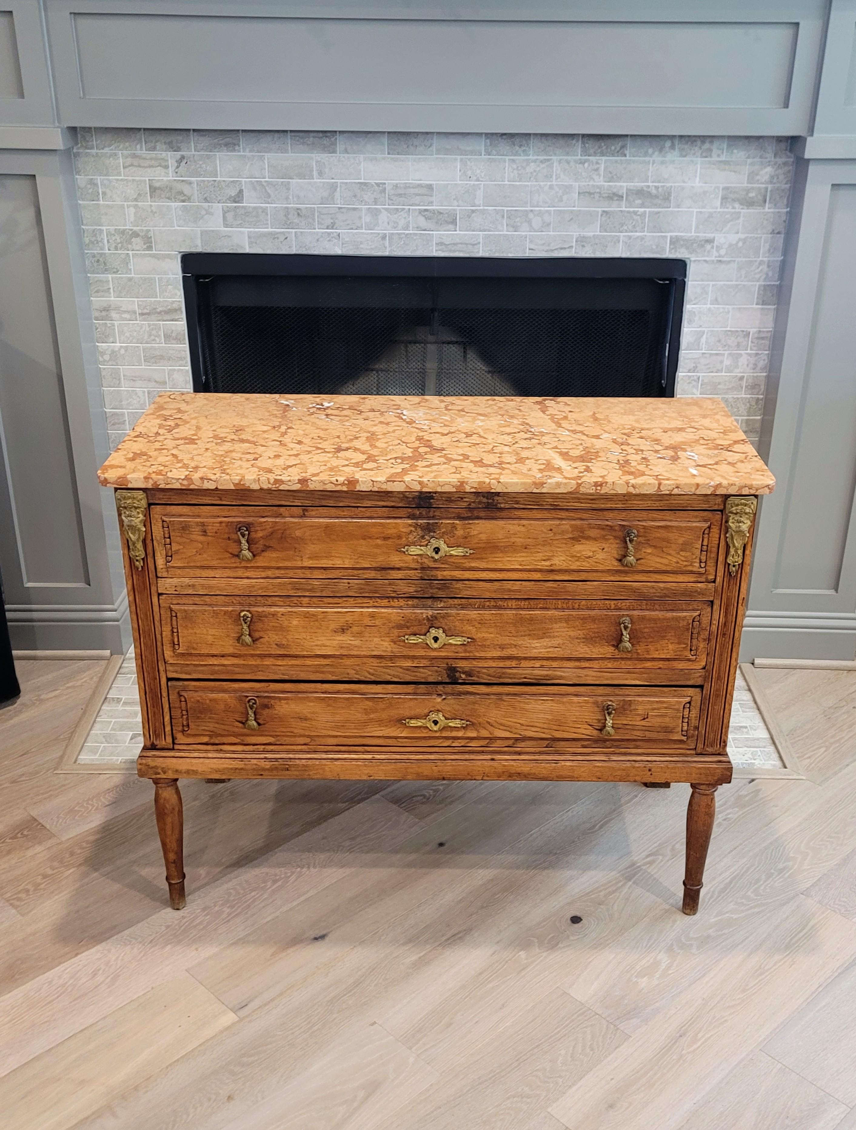 Refined elegant simplicity, comfortable rustic warmth and historical European old world charm. 

A handsome antique, circa 1800, country French marble-topped ormolu mounted oak chest of drawers commode with outstanding patina.

Born in Provincial