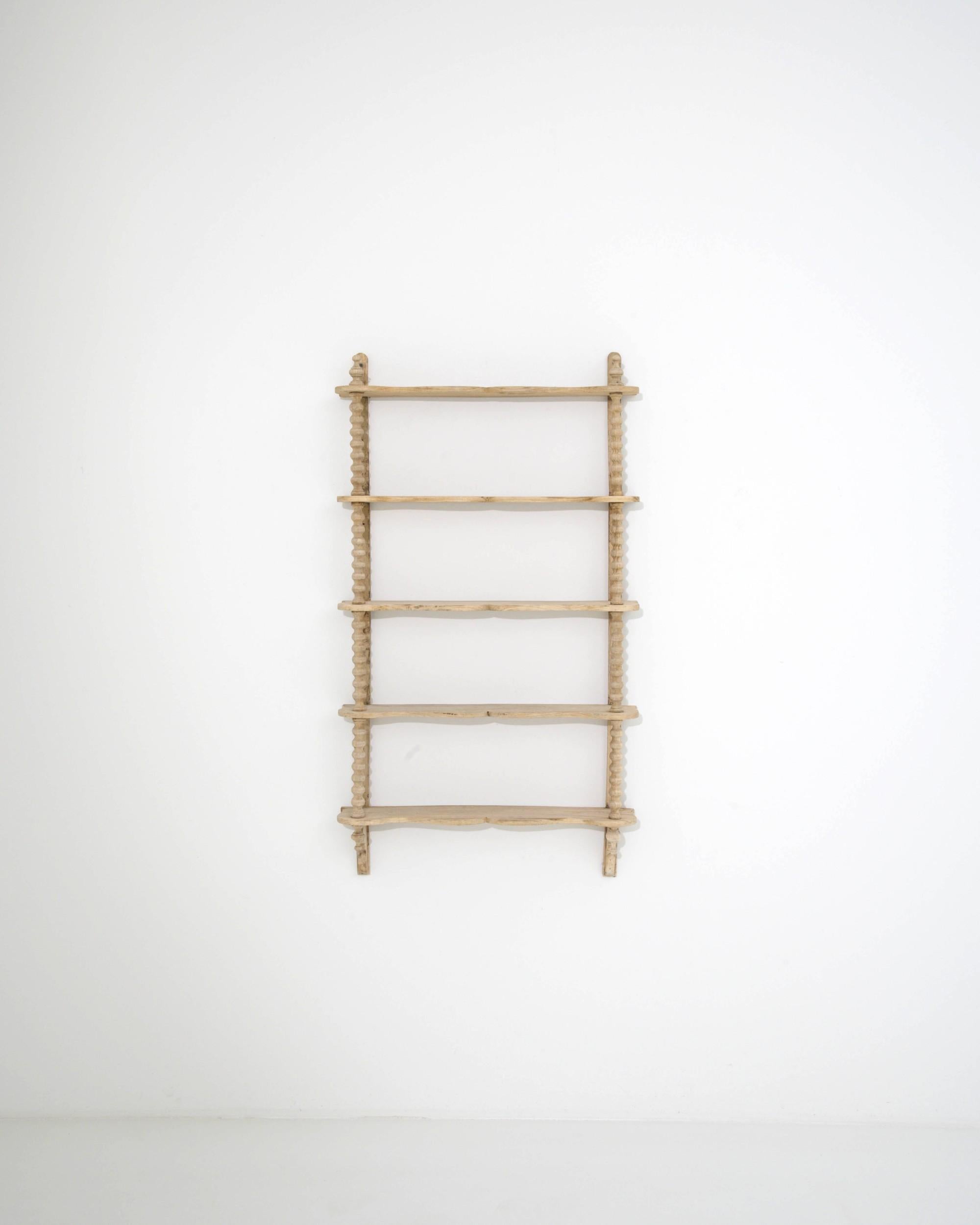 The design of this antique oak wall shelf ingeniously combines practicality with decorative charm. Built in France in the 1800s, the fresh natural finish of the restored wood and the light simplicity of the design speak to a Provincial sensibility: