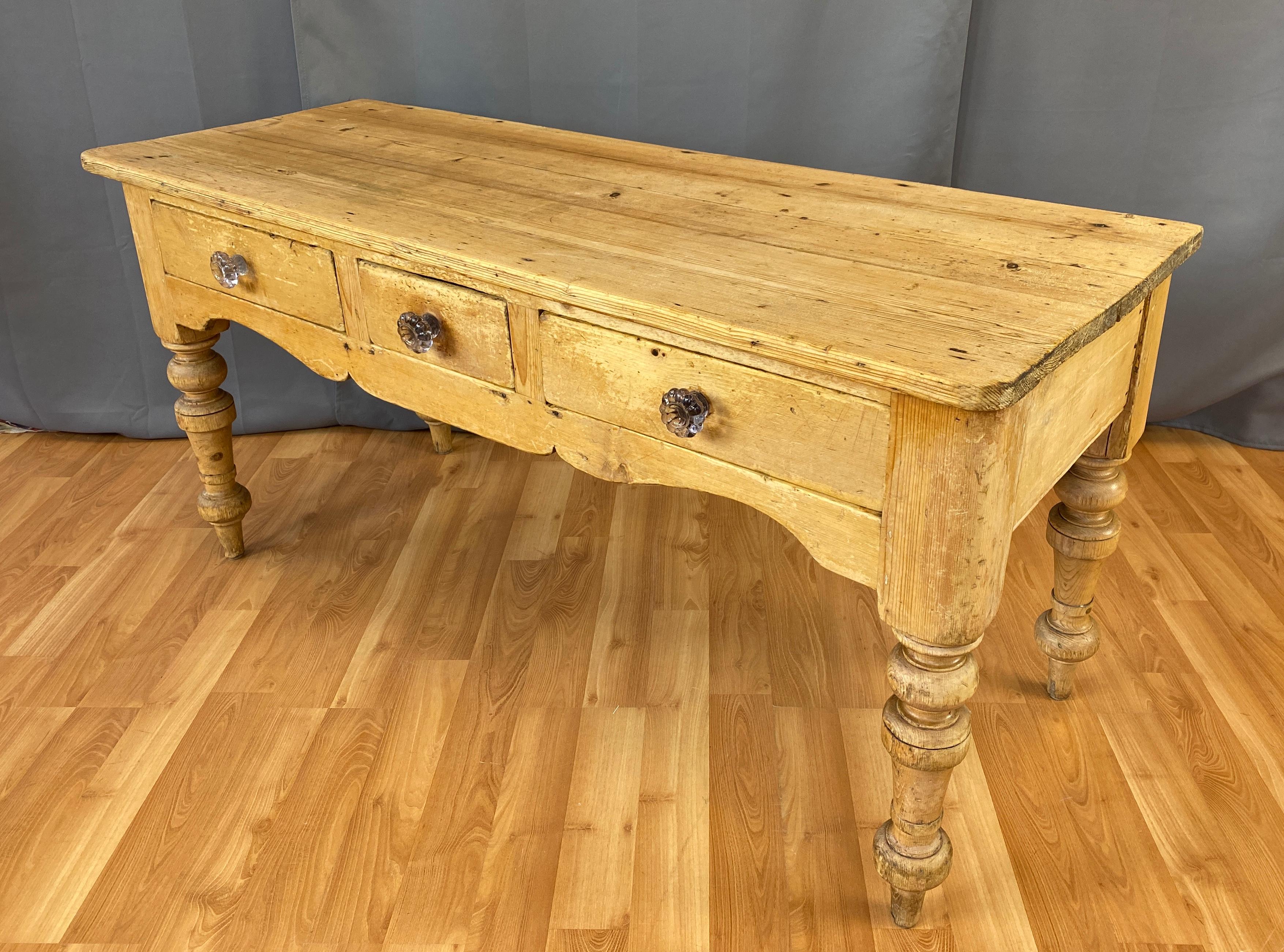 Offer here is a wonderful 19th century French farmhouse table, that's rich in details. 
Hand carved scalloped apron, three drawers which retain their original lobed glass pulls. 
The pulls have aged to a light lavender. It all stands on