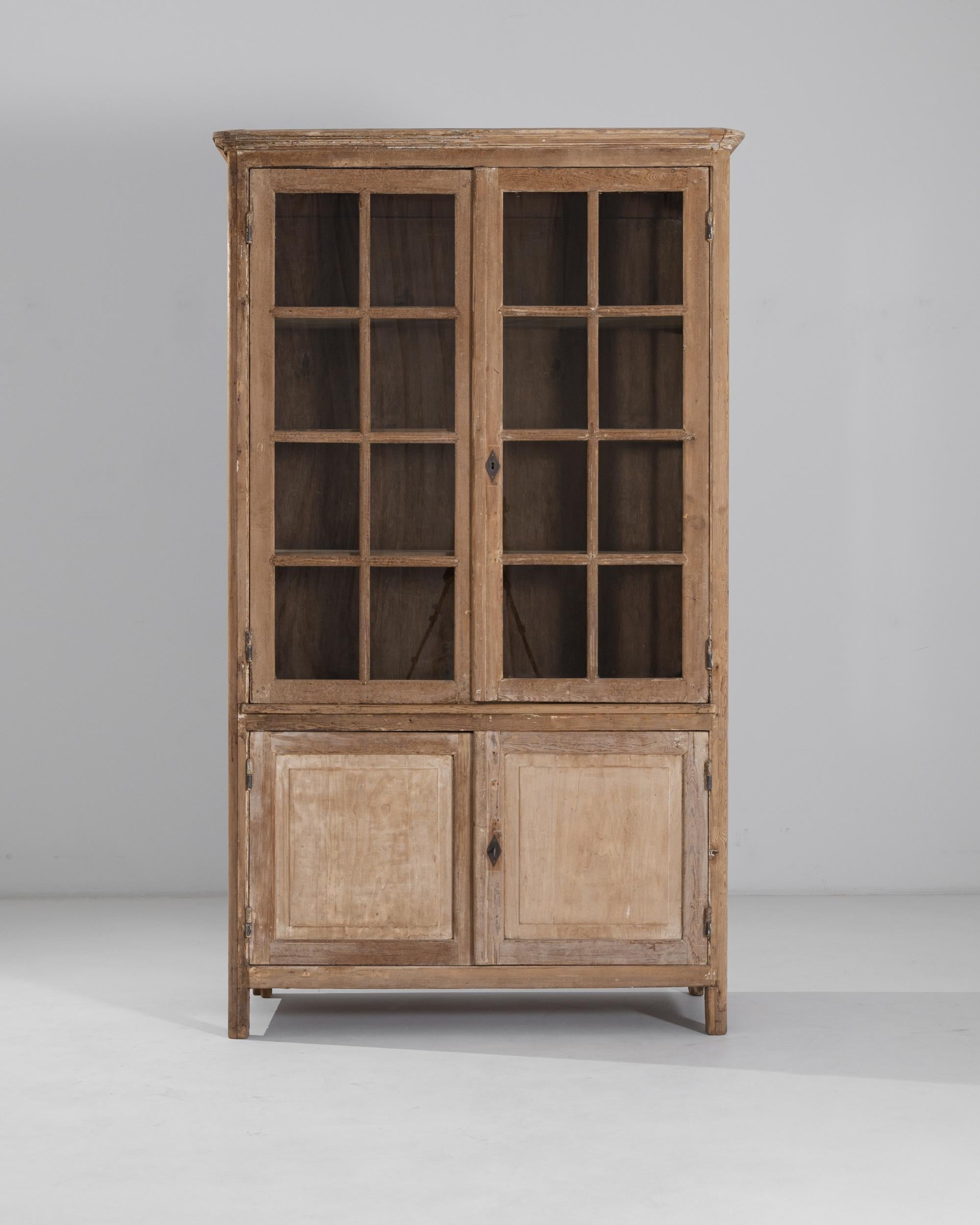 The graceful simplicity of this antique provincial vitrine gives it an evergreen appeal. Made in France in the 1800s, mullioned windows on four sides flood the upper cabinet with natural light, making it the perfect display case for treasured