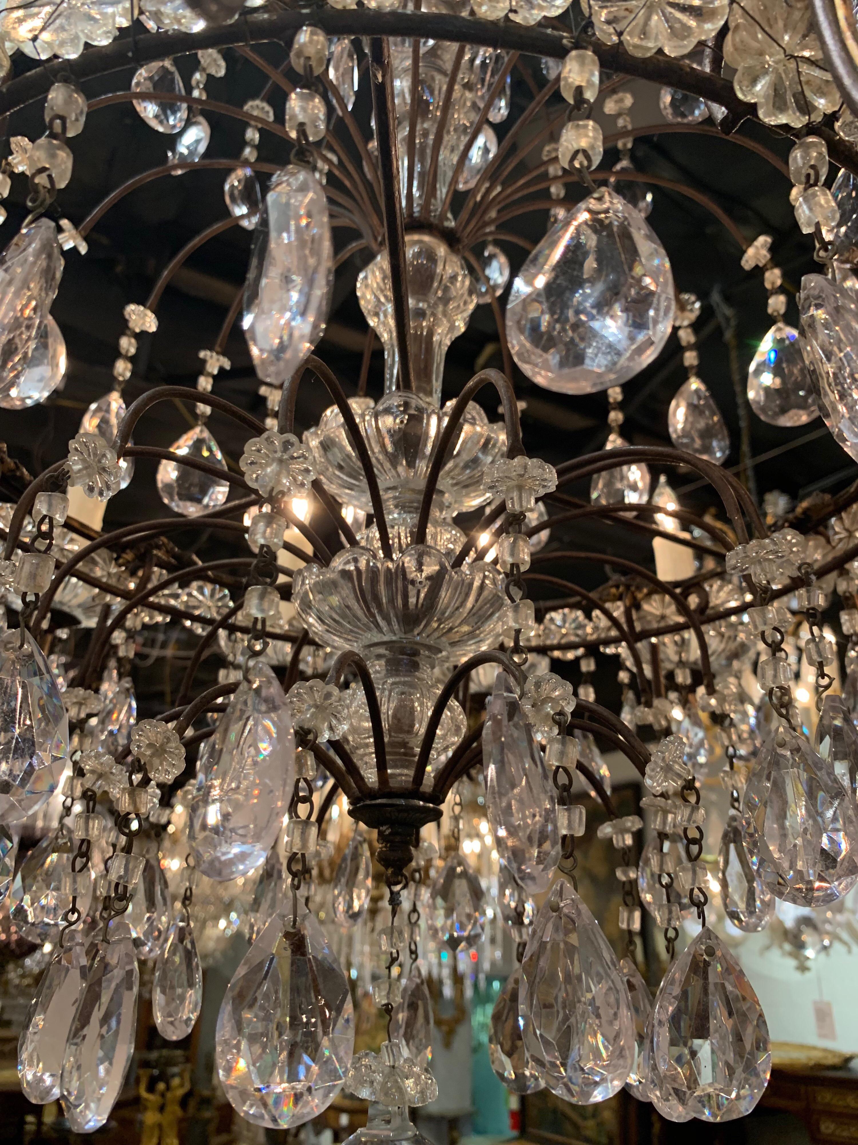 Stunning 19th century waterfall style crystal chandelier from France. The chandelier has 12 lights and a multitude of prisms and beads. Lovely shape as well! Just re-wired, cleaned, and ready to hang. Matching chain and canopy included.
   