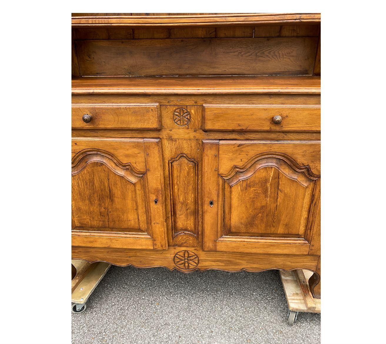 This 19th century French cupboard would make an excellent addition to any kitchen or dining space! It has three roomy shelves, perfect for dishes, and two cabinets and two drawers for storage underneath. The patina on this piece is excellent as well
