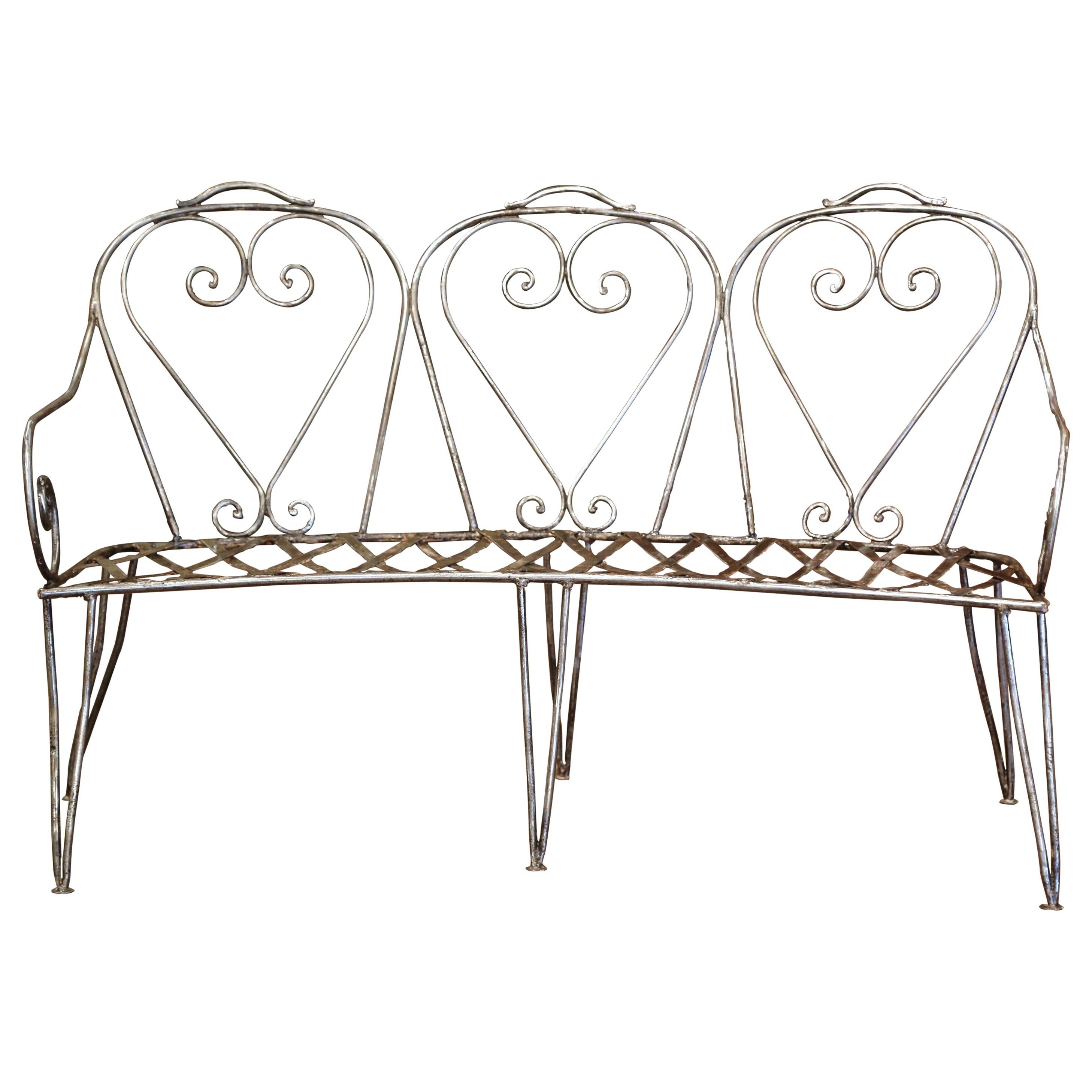 Add extra seating to an outdoor space, porch or patio with this elegant antique iron bench. Crafted in northern France circa 1860, the rounded bench sits on six tapered and angled legs and could accommodate three people. The delicate garden bench
