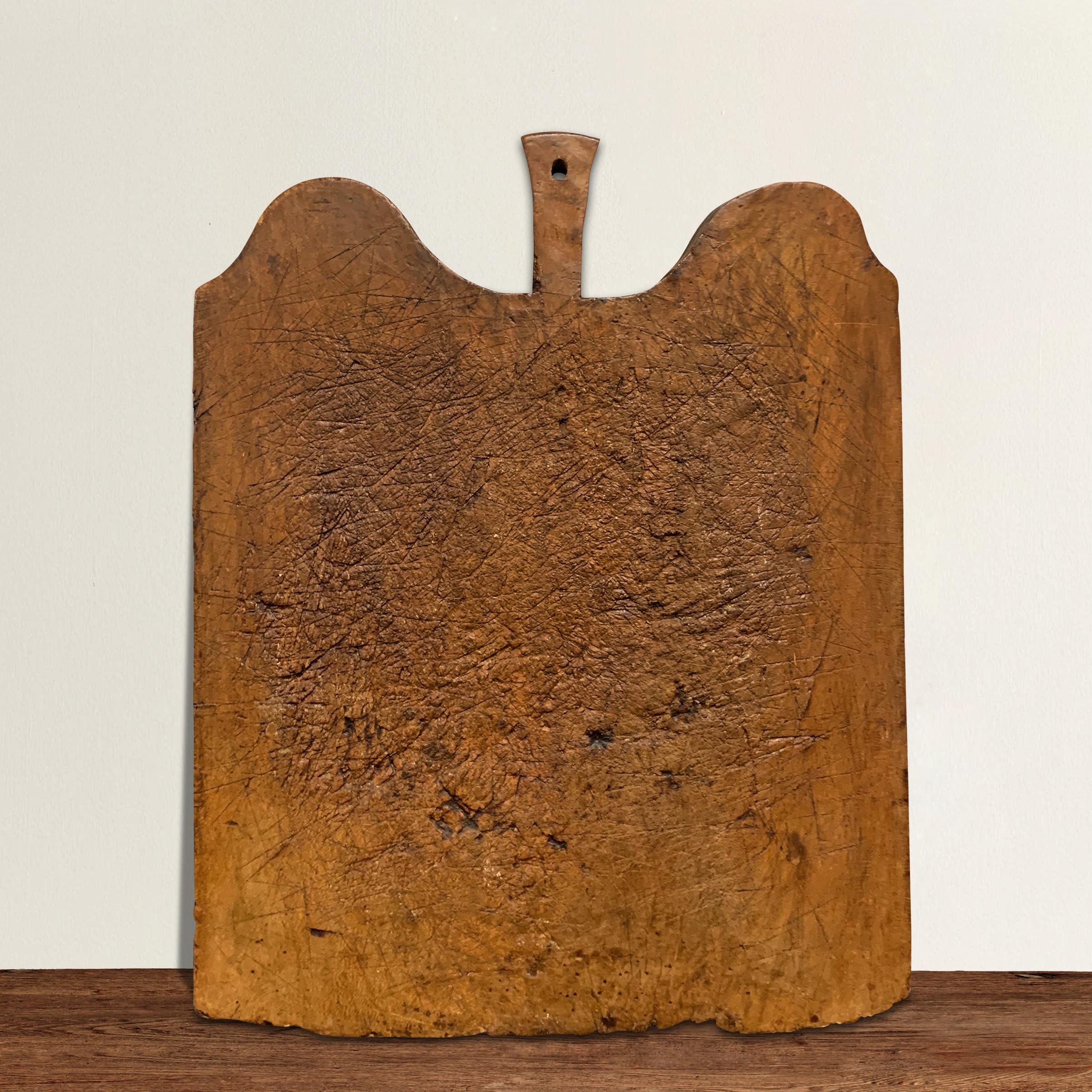 A rather large 19th century French cutting board with a wonderfully sculptural form and hundred, if not thousands, of knife marks from a century of use. There’s a slight warp to the board, but we think it adds to the charm and personality of the