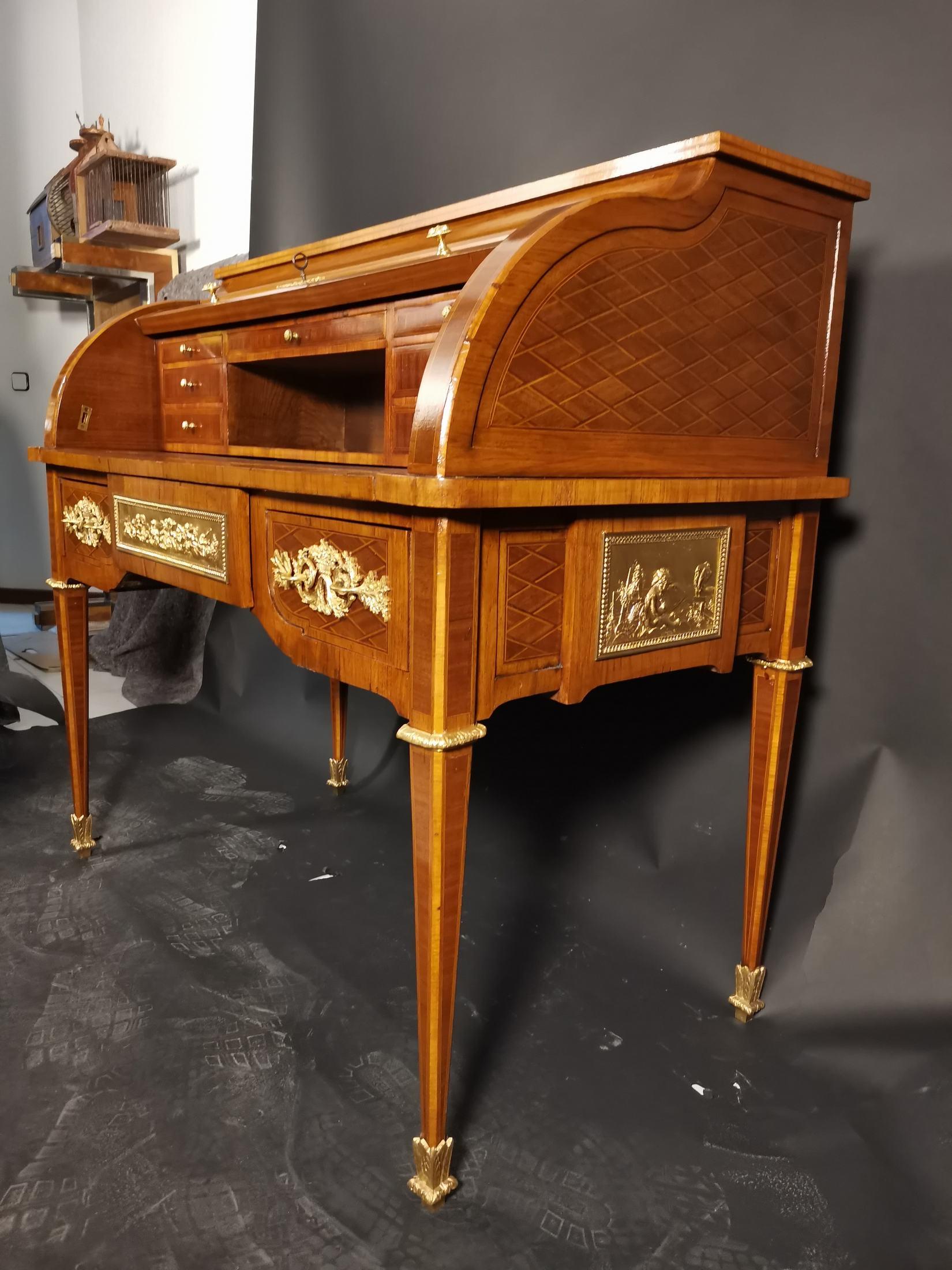 19th century cylinder desk in Louis XVI style Marquetry,
rich gilded bronze ornamentation. 
Three drawers in the belt. 
The office is open to the public and has a fold-out table for credit that measures; this shelf is upholstered in brown