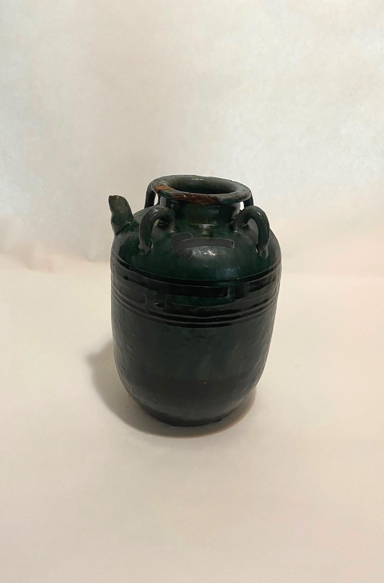 Esta antigua jarra de loza francesa, con su vidriado verde oscuro y negro, data del siglo XIX, y originalmente se habría utilizado para almacenar sal. Con cuatro asas y pico vertedor, esta jarra grande, hecha a mano, está en perfecto estado.
