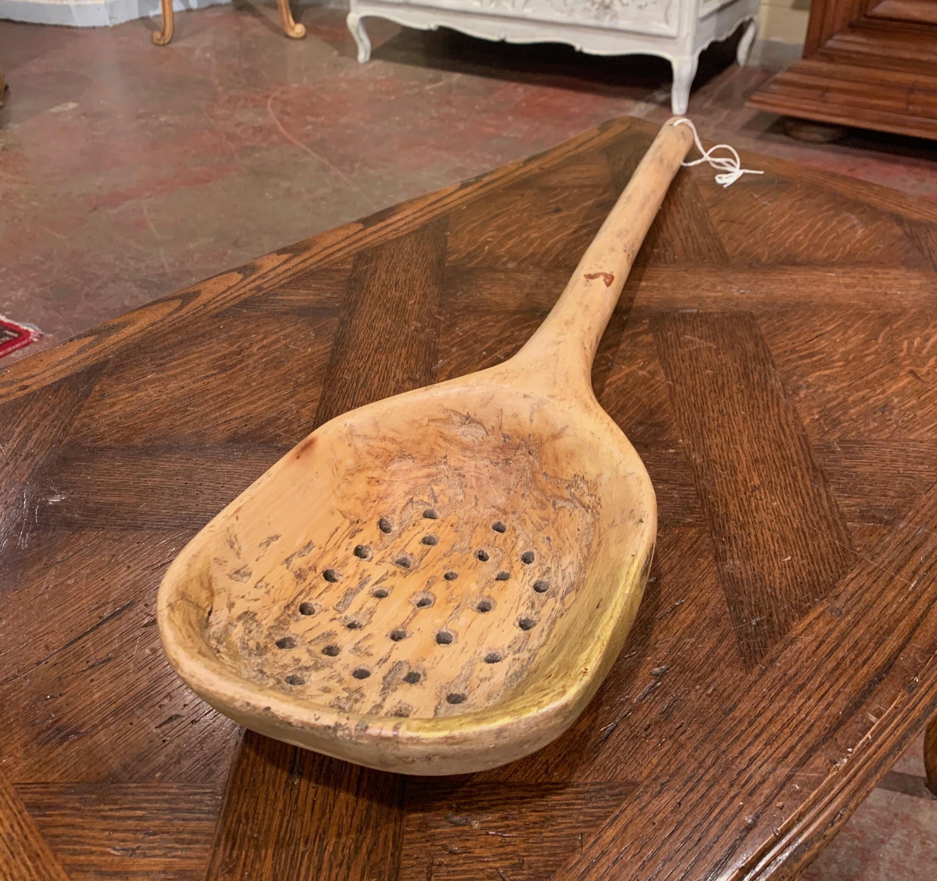 Decorate a kitchen wall with this large country spoon; carved in France circa 1880, the utensil with holes was used for grain in the old days. The long serving spoon is in excellent condition with a rich light walnut patina.
Measures: 31