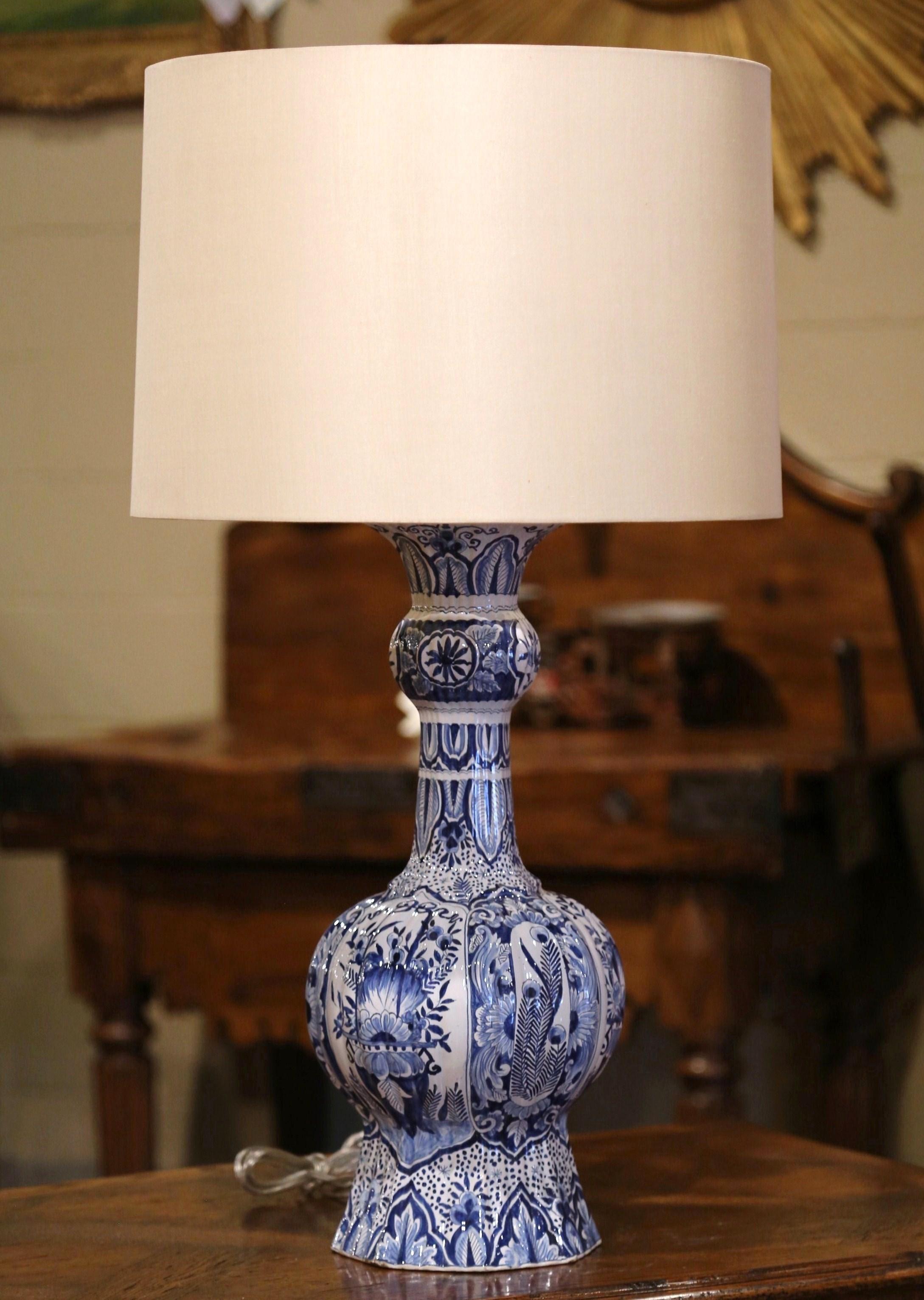 Decorate a console or a commode with this elegant antique lamp base, crafted in France, circa 1880, the tall colorful faience lamp has new wiring with two lights and is hand painted with floral and leaf motifs in the traditional blue and white delft