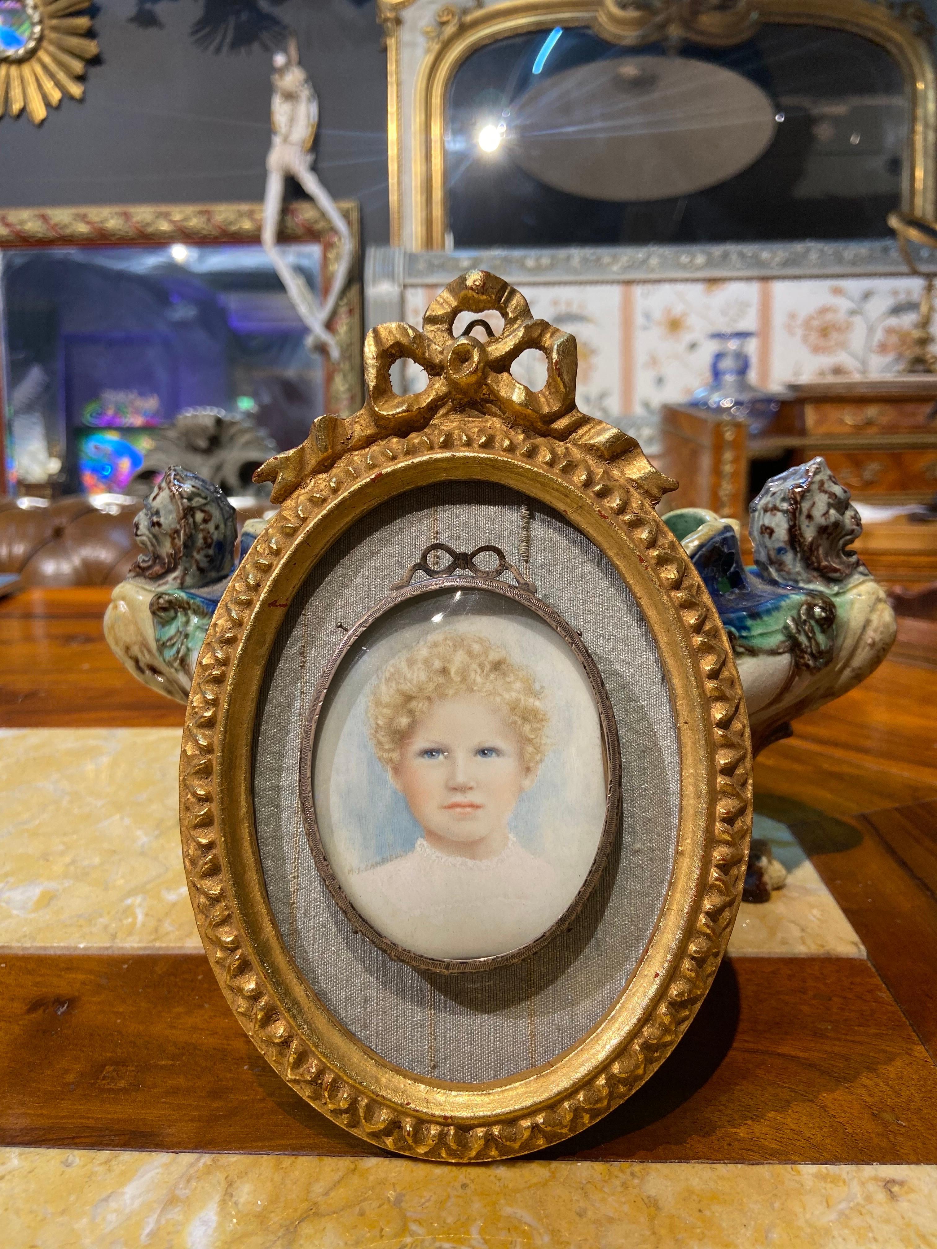 Delicate and very beautiful small painting of a portrait of a young child in bright colours. It is framed in two separate frames one metal and one gilt wood with a ribbon on the top in Louis XVI style. Lovely piece of art!
France, circa 1860.