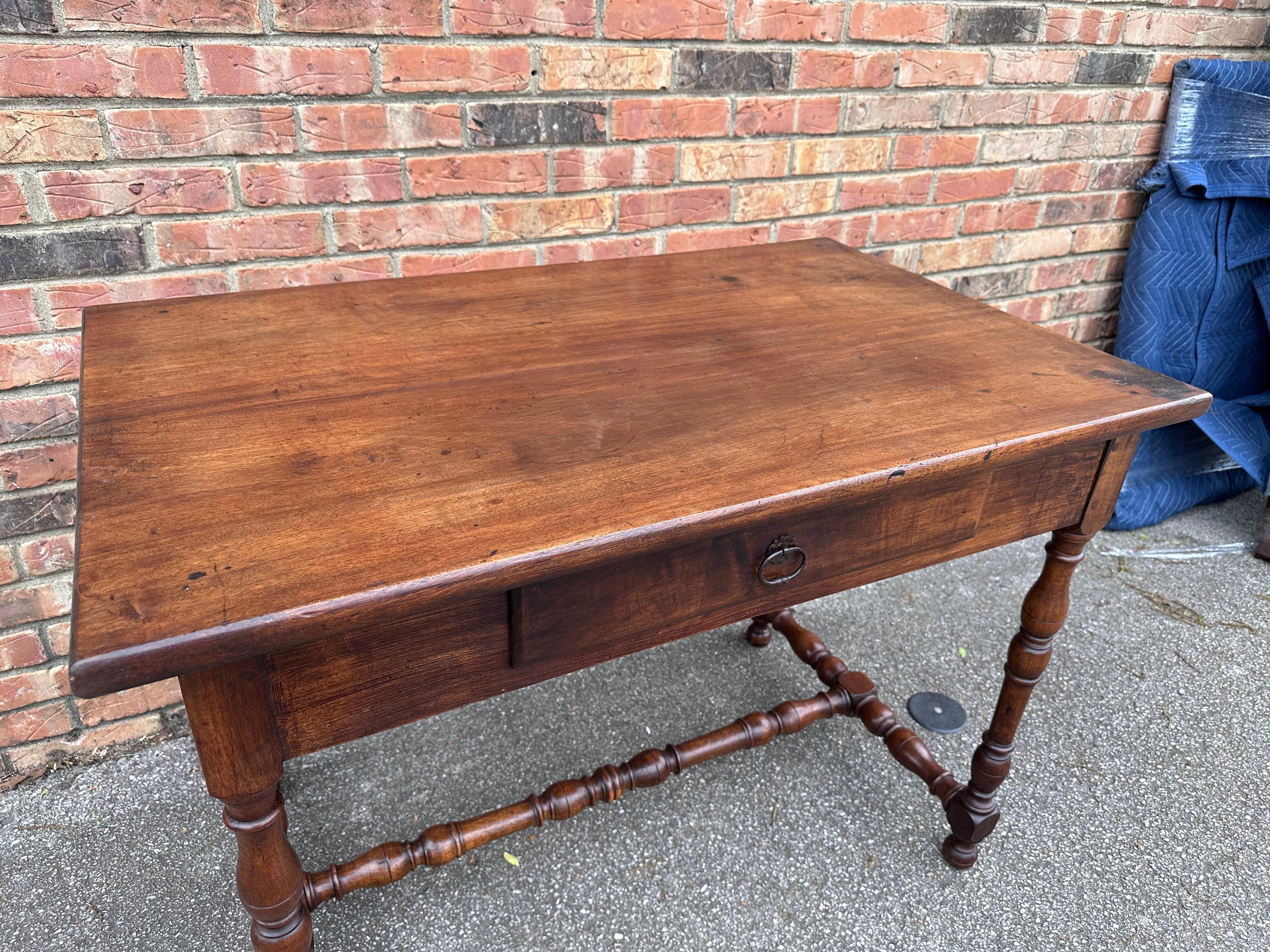 This is a beautiful early 19th century French desk are what we would probably use as an end table or side table, Amazing patina and age showing everywhere, resting on four turned legs as well as a stretching in the center on the bottom a beautiful
