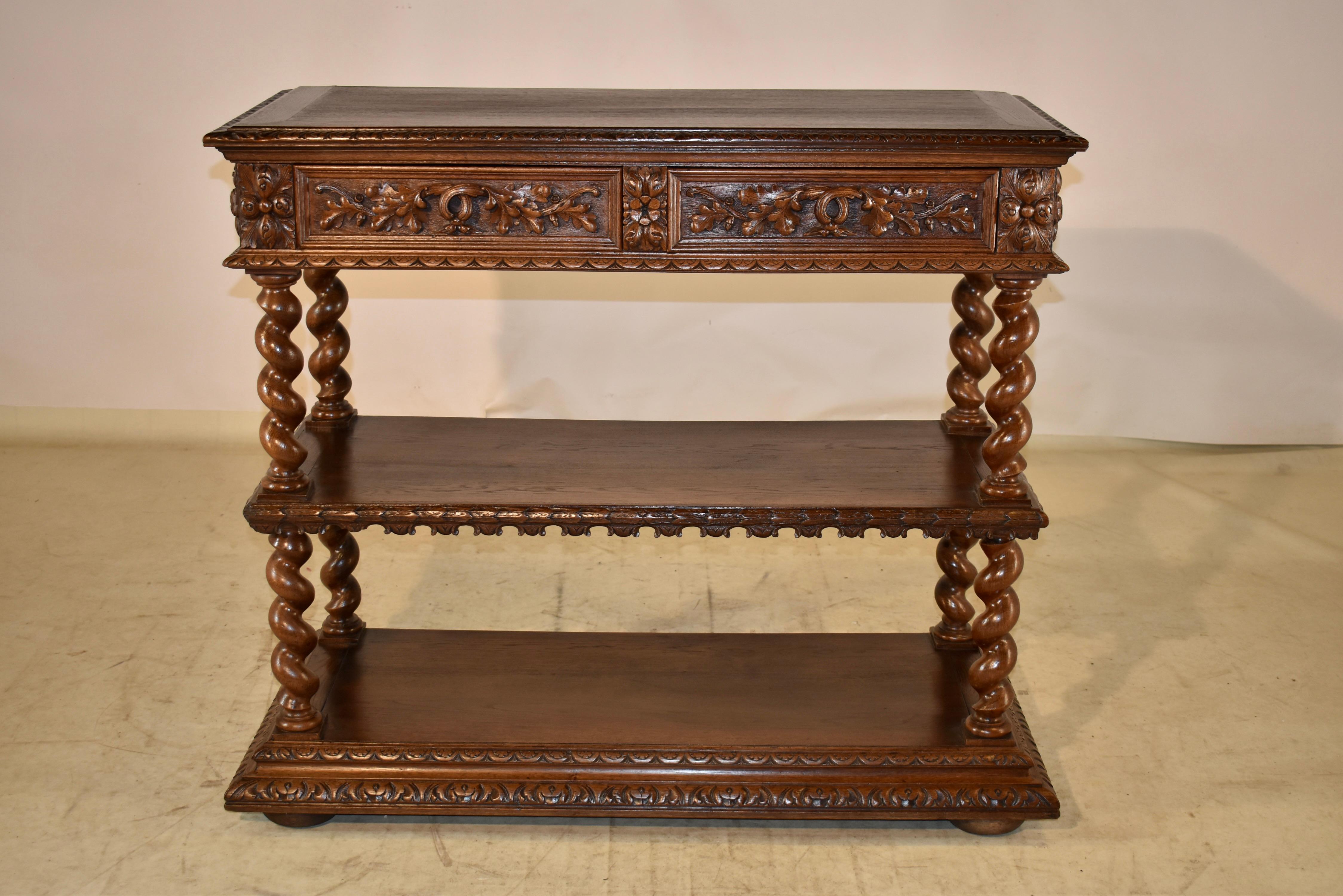 19th century oak dessert buffet from France. the top is banded and has a beveled and hand carved edge, following down to paneled and hand carved decorated aprons on the sides and two drawers in the same style in the front of the piece. The drawers