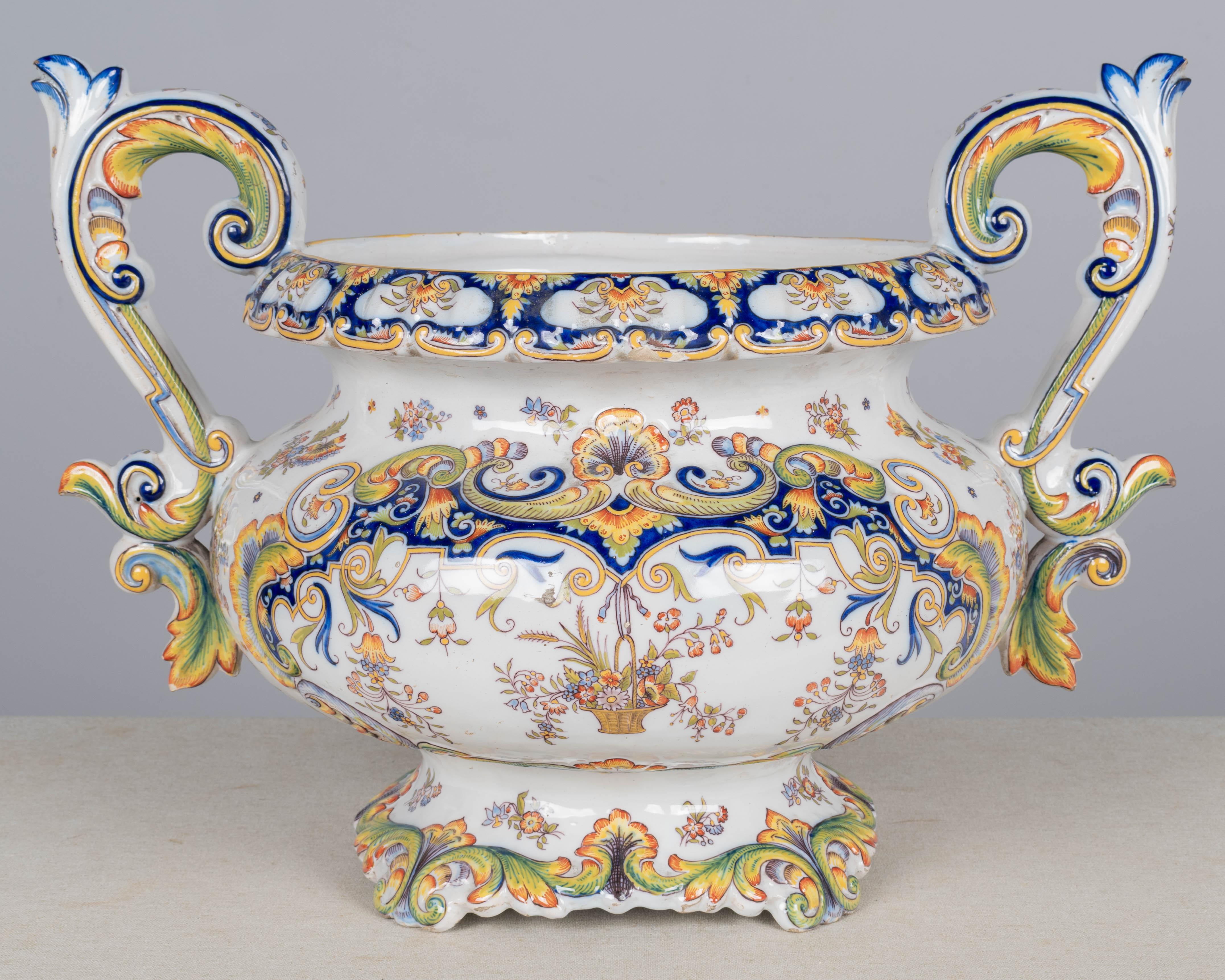 Grande cachepot, o fioriera, in maiolica francese Desvres del XIX secolo, con forma di ciotola con piede e manici scultorei a voluta. Dipinto a mano in un tipico disegno floreale con bellissimi colori vivaci di blu, verde, giallo e arancione su