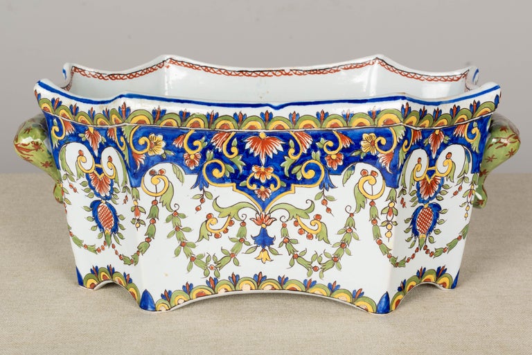 A 19th century French Desvres faience jardinière, or planter. Hand painted in typical floral design with beautiful vivid colors of blue, green, yellow and red on white ground. Footed bowl with nice form and sculptural handles. Fourmaintraux-Freres